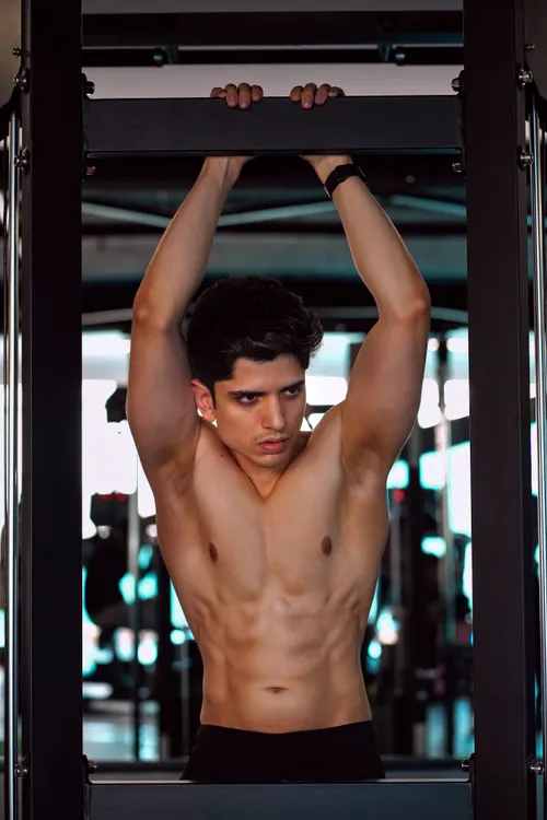 Athlete performing strict pull-ups on a gym bar