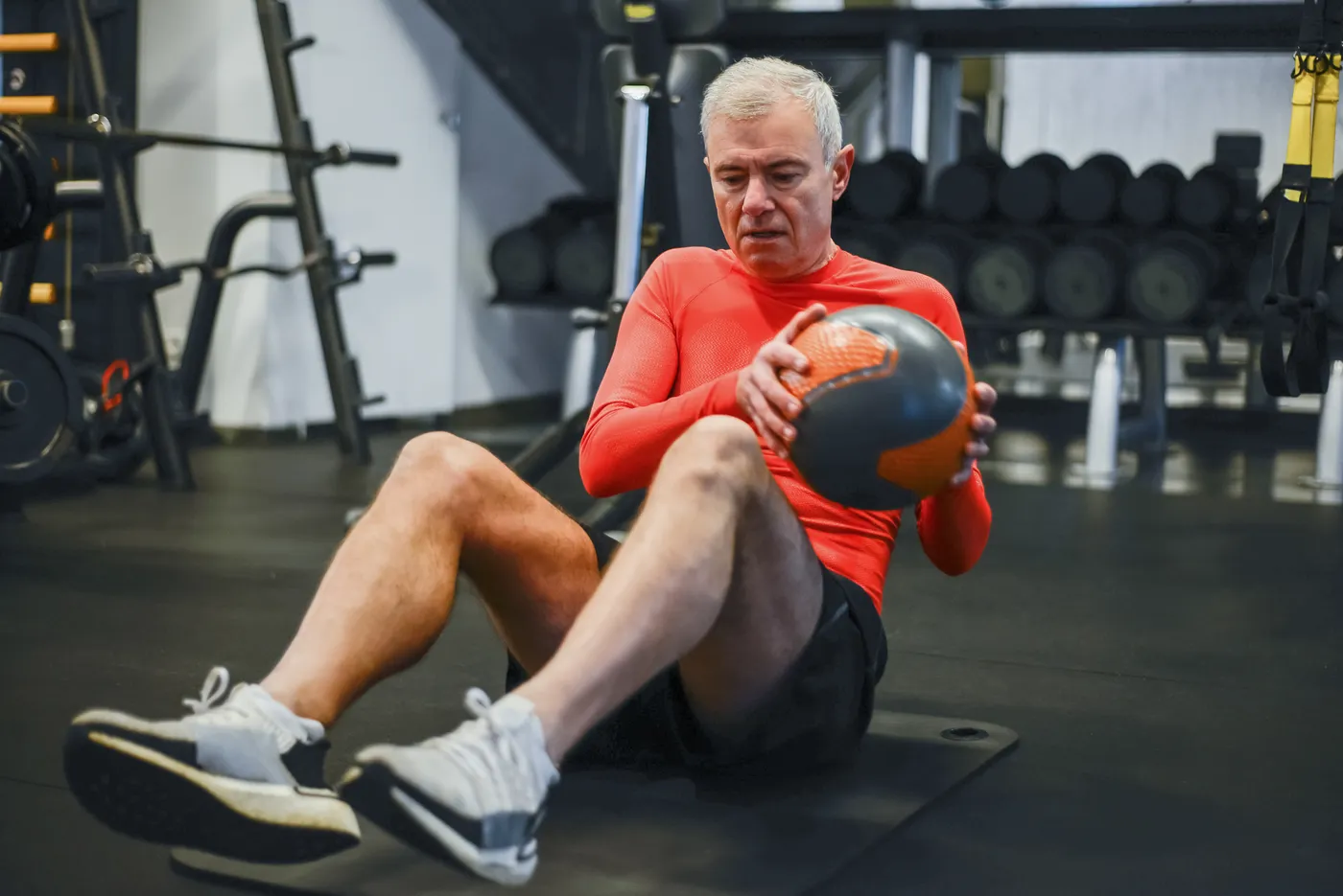 Older man performing a controlled medicine-ball strength movement