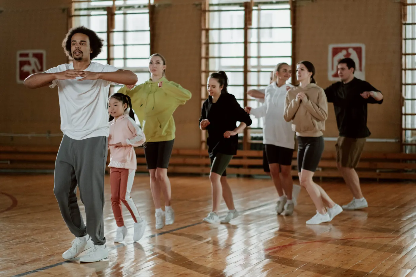 Group performing coordinated movement in an indoor fitness class