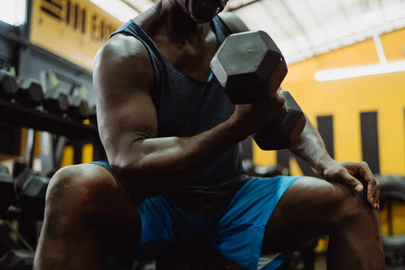 Muscular man training with dumbbells in a gym