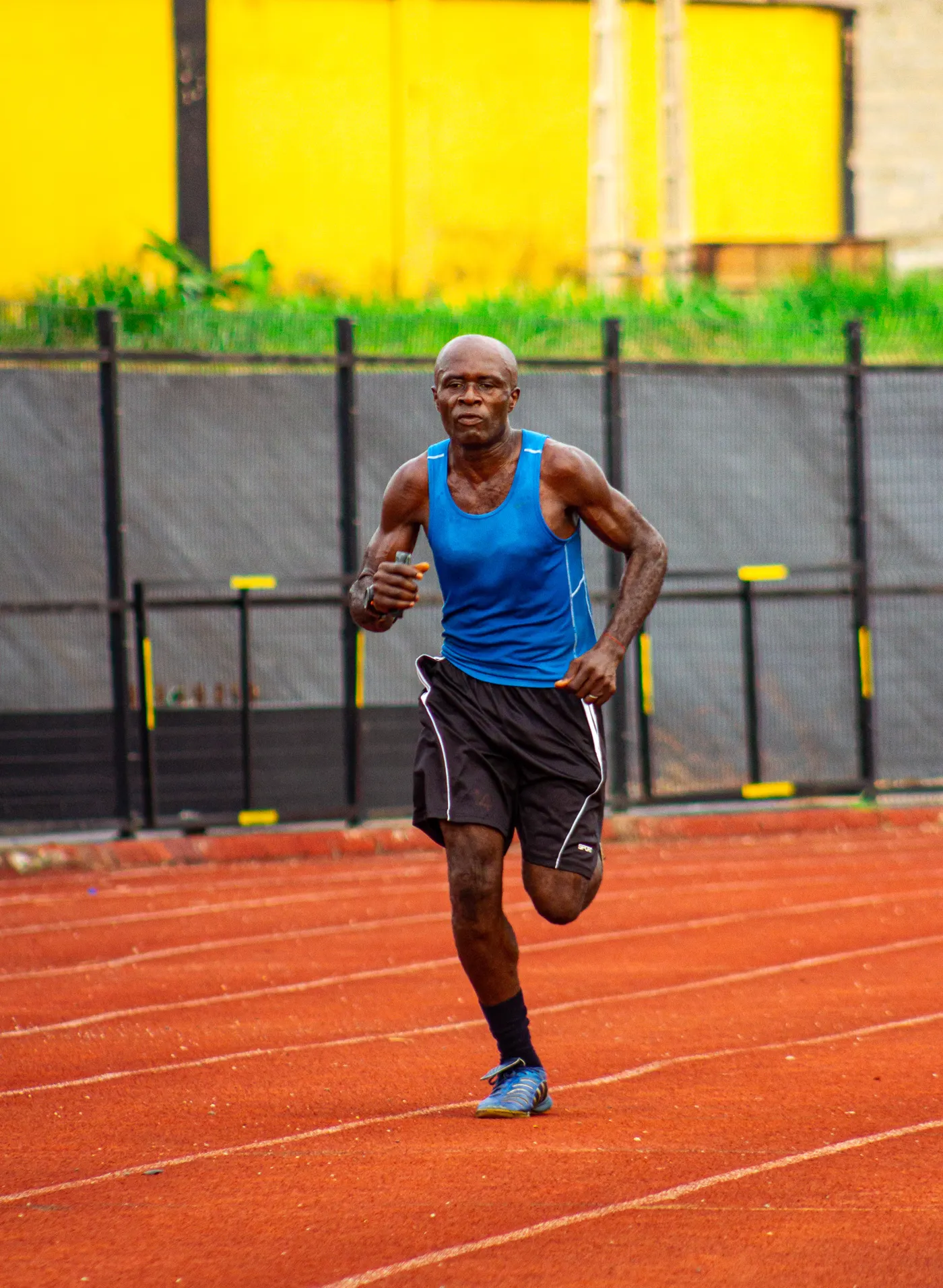 Man running in blue sportswear on an outdoor track