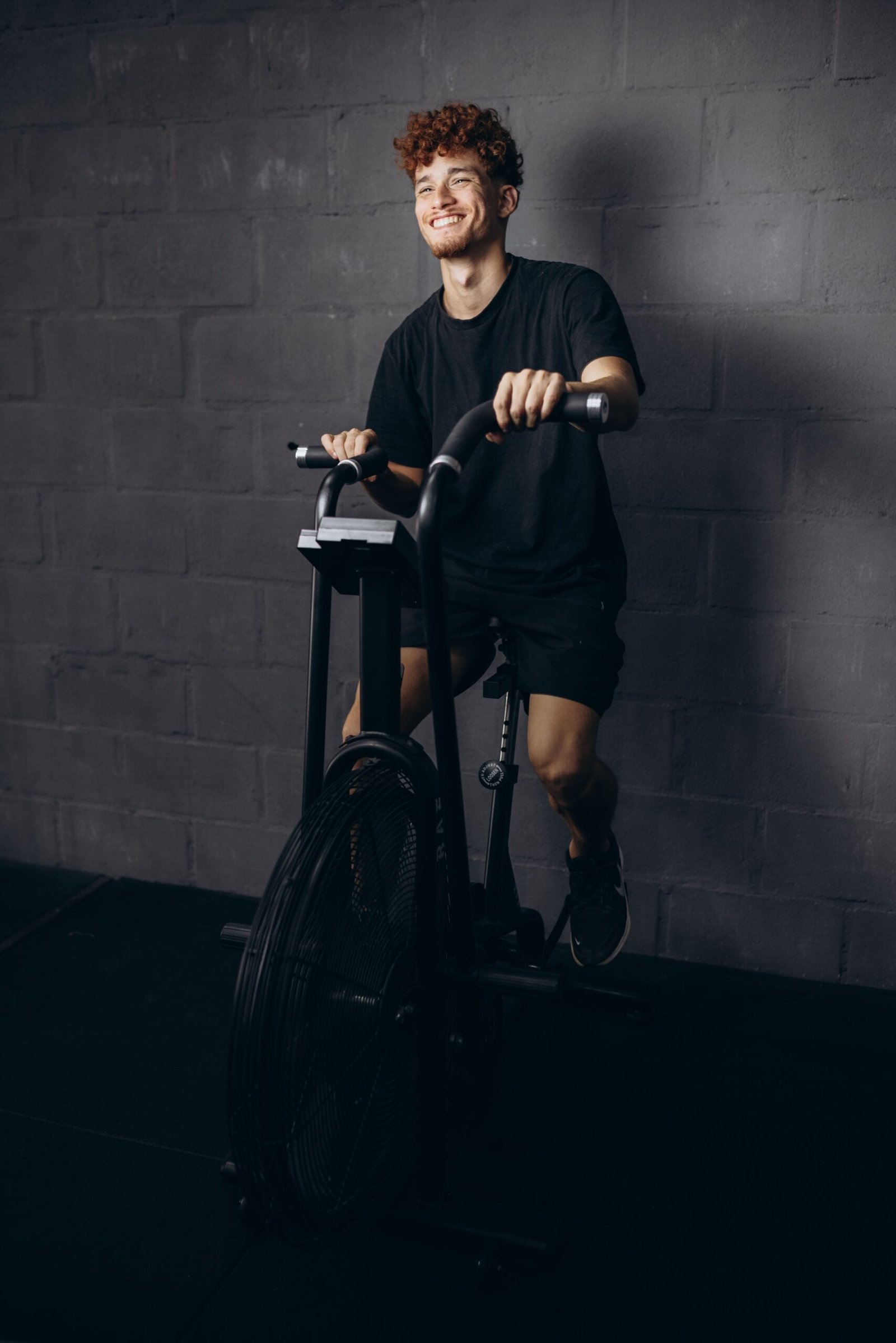 Man smiling while exercising on an air bike