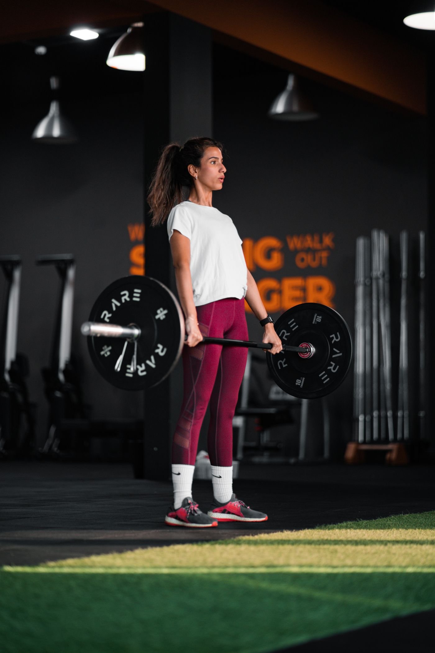 Woman standing upright after a barbell deadlift