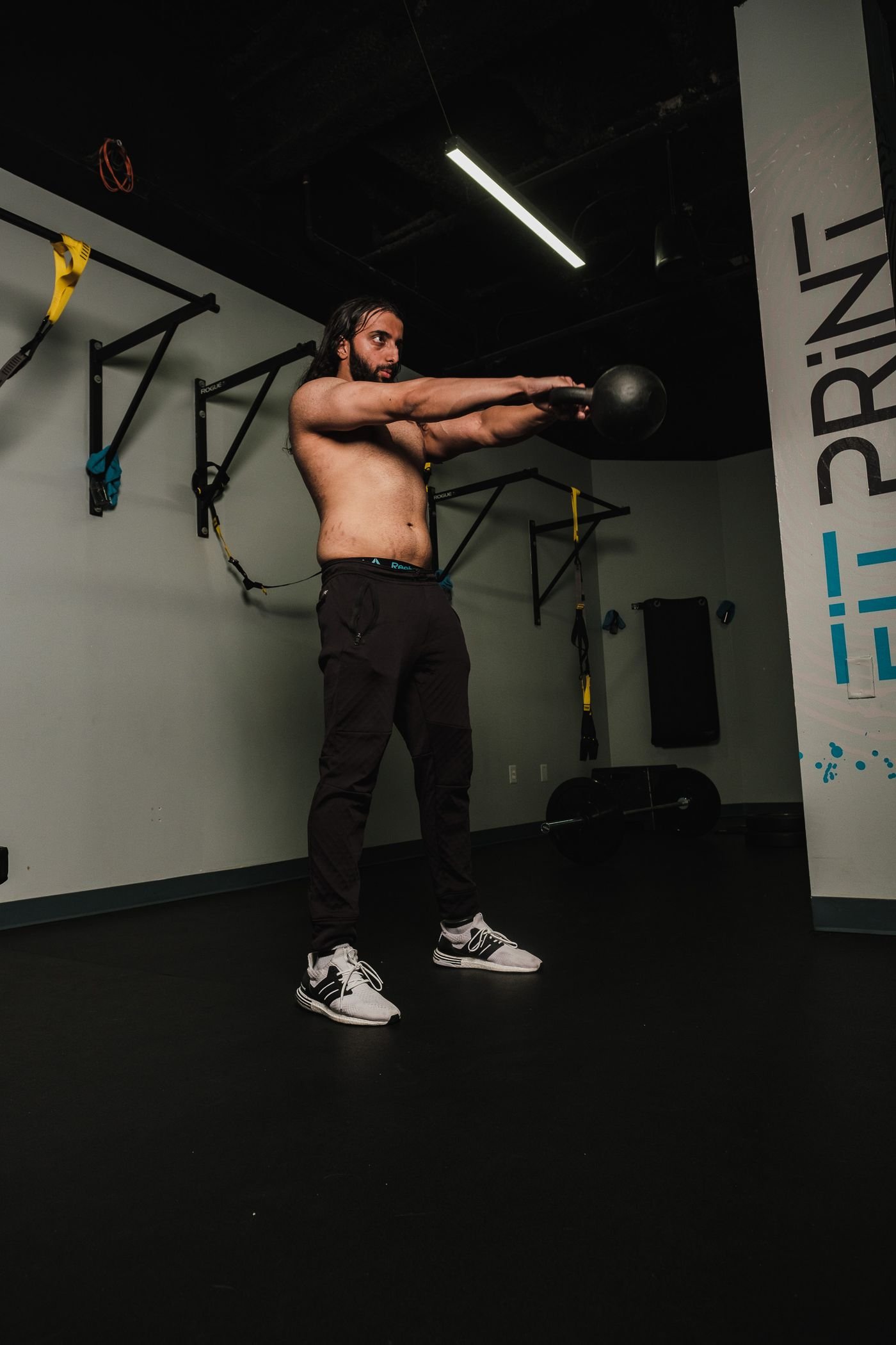 Athlete performing a kettlebell swing indoors