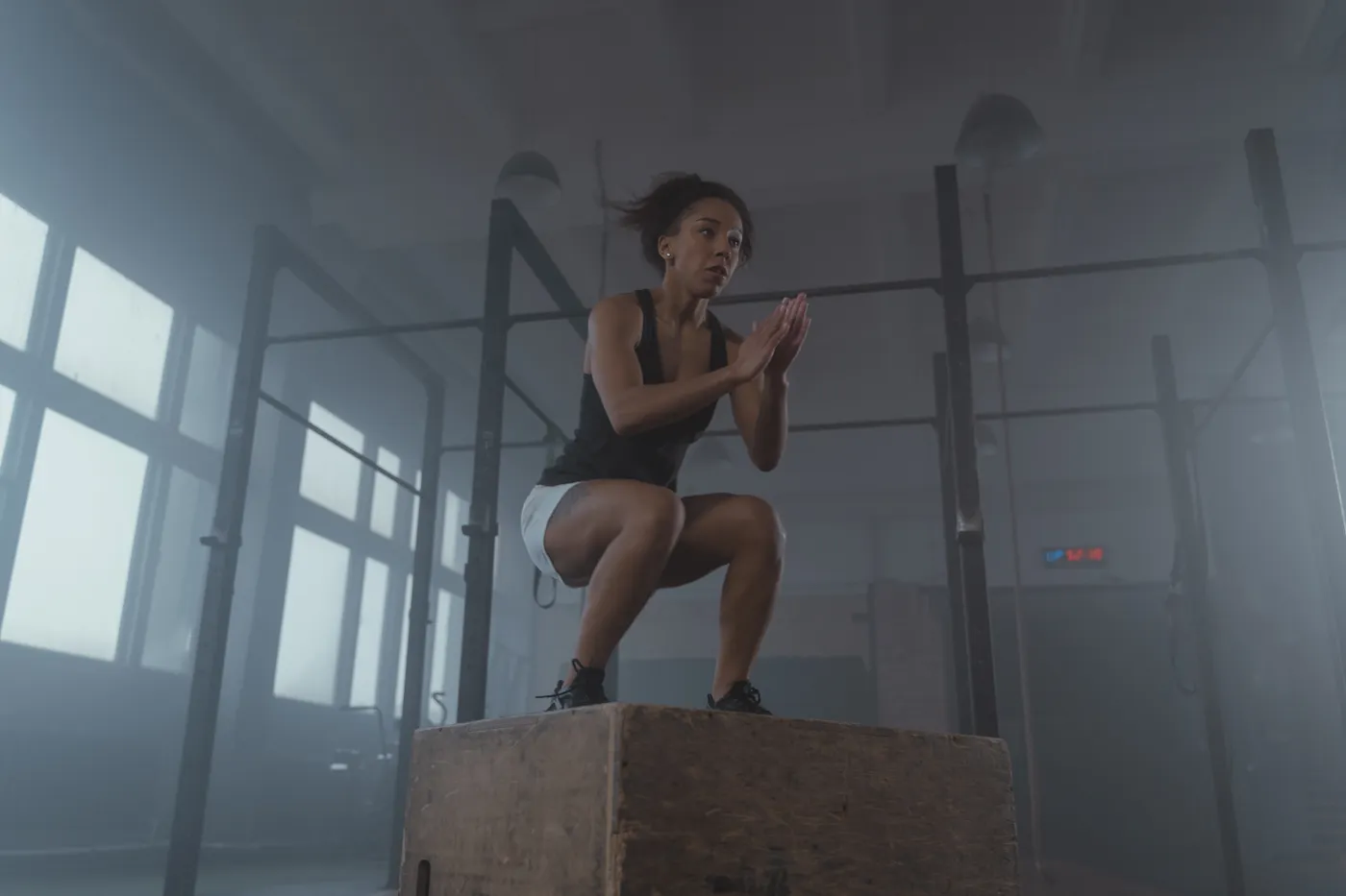 Athlete practicing an explosive box jump in a gym