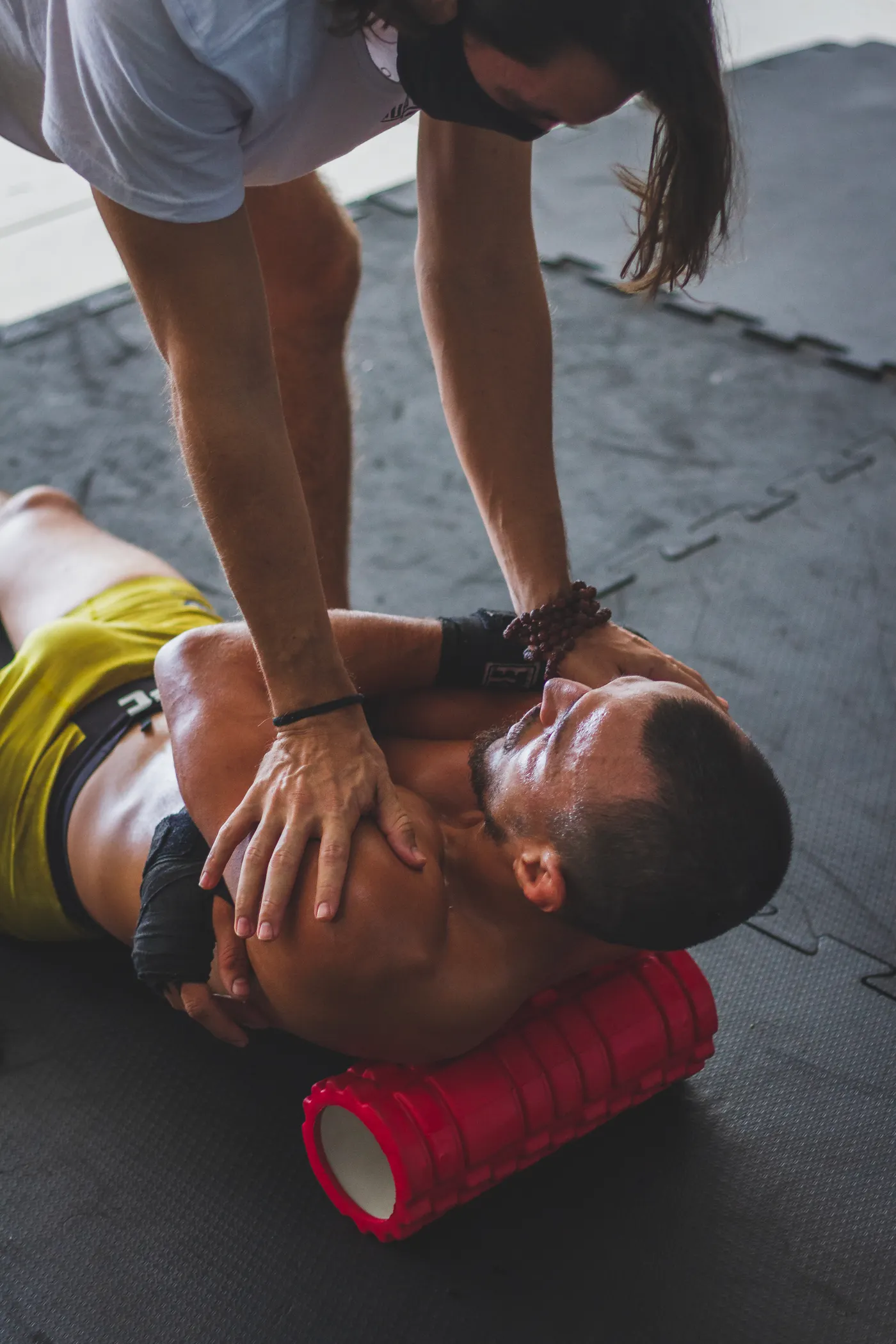 Athlete using a foam roller with a trainer