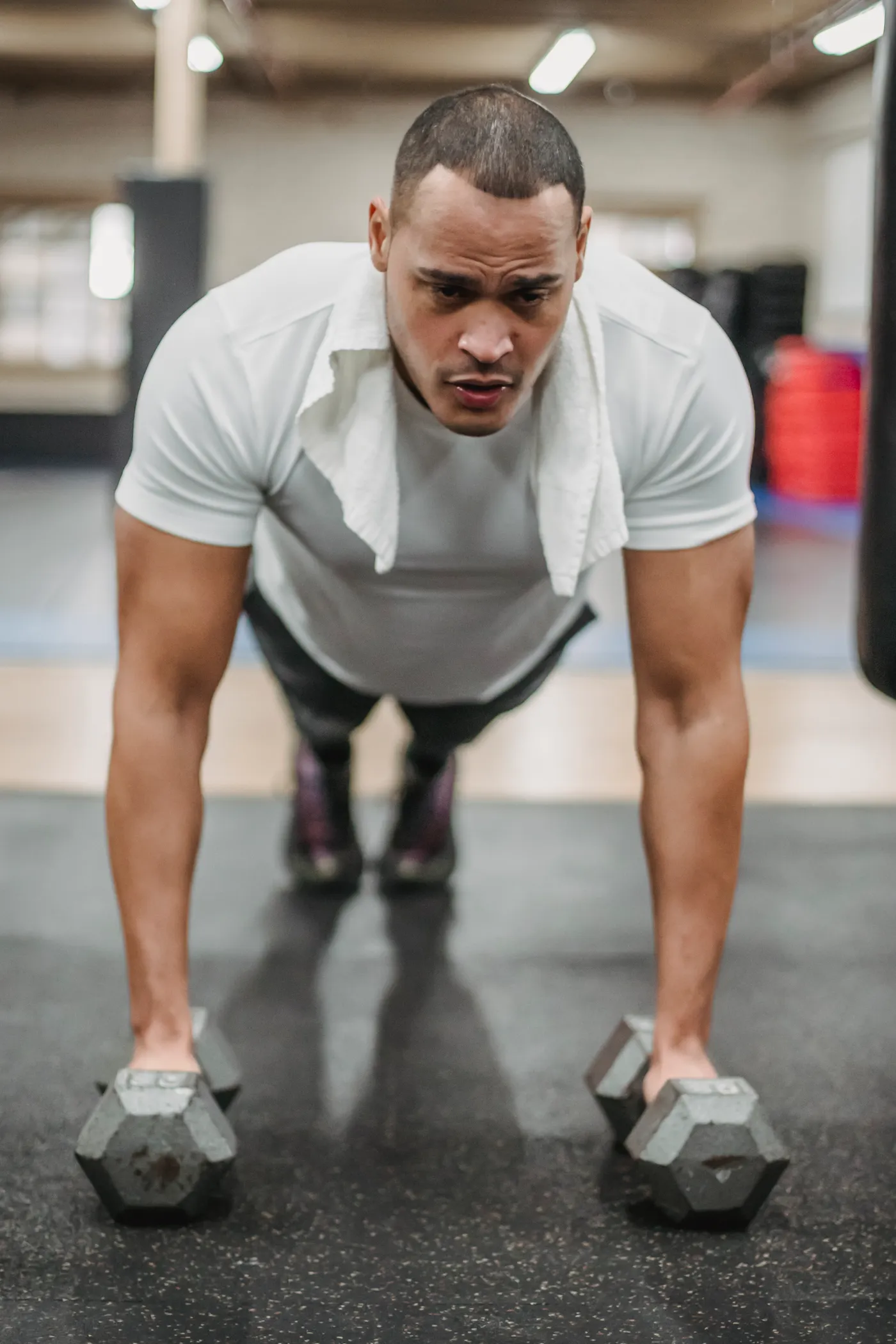 Athlete performing a push-up using dumbbells in a gym