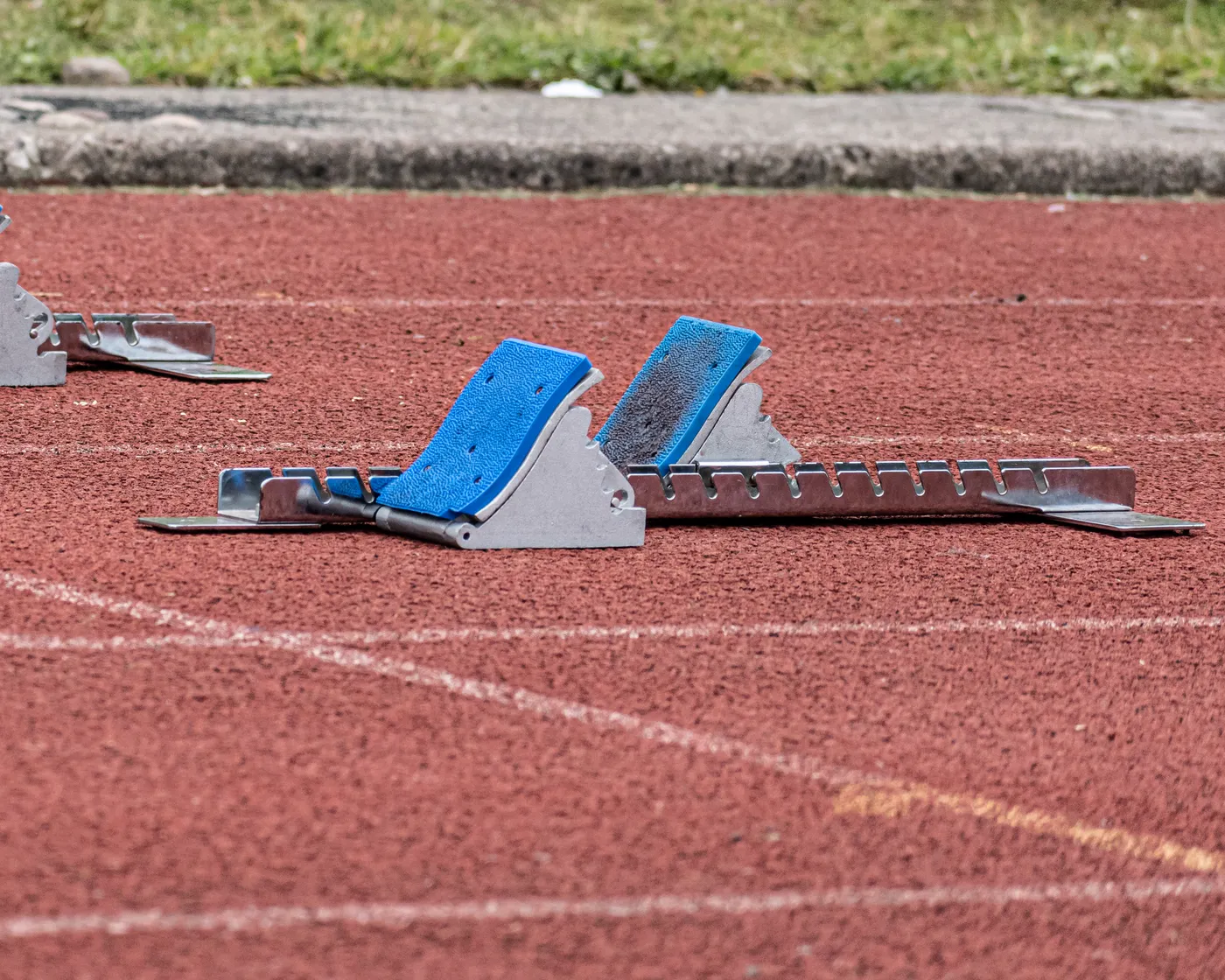 Starting blocks placed on a red track before a sprint session