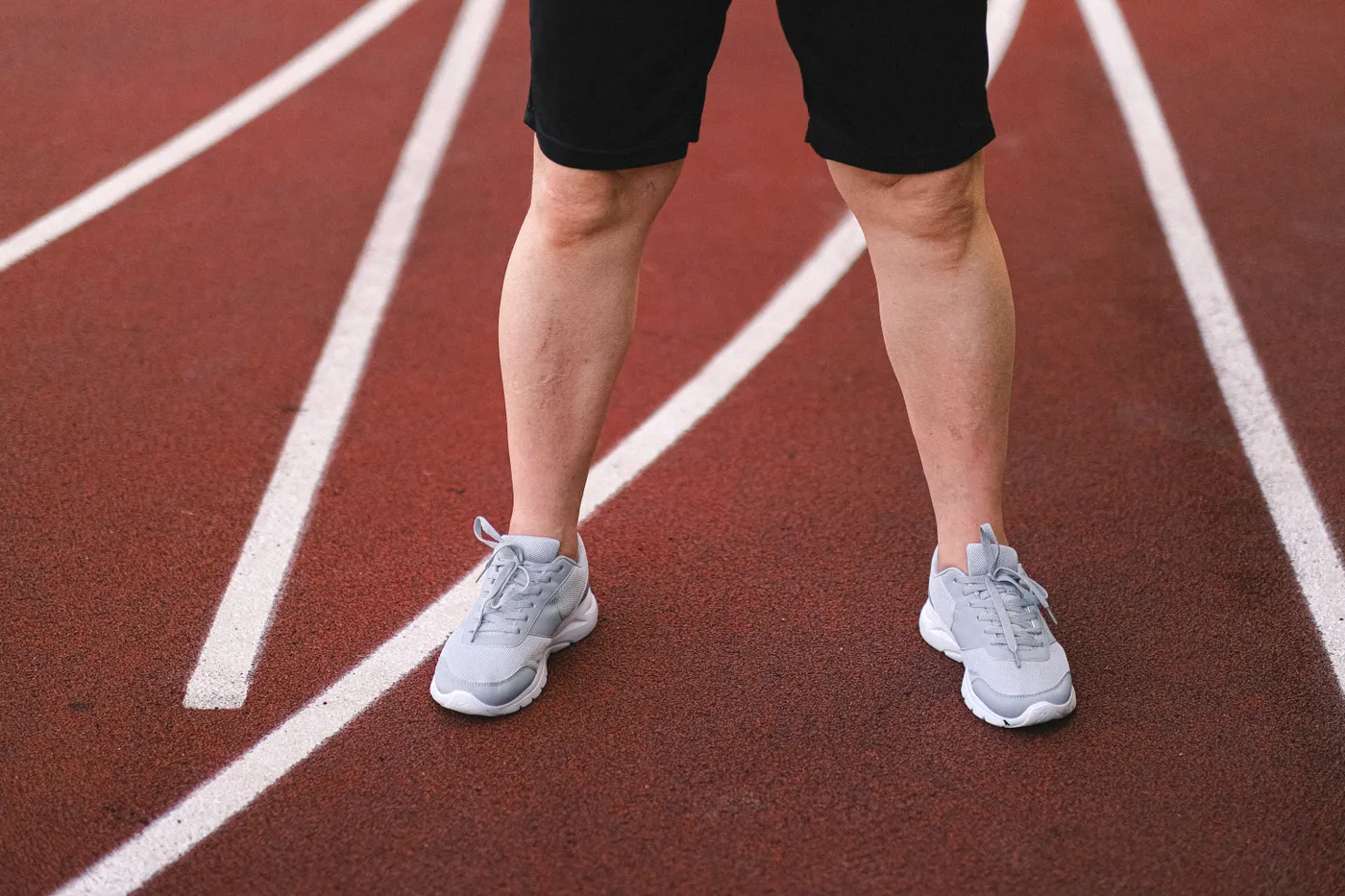 Close-up of a runner's lower legs and shoes on a track