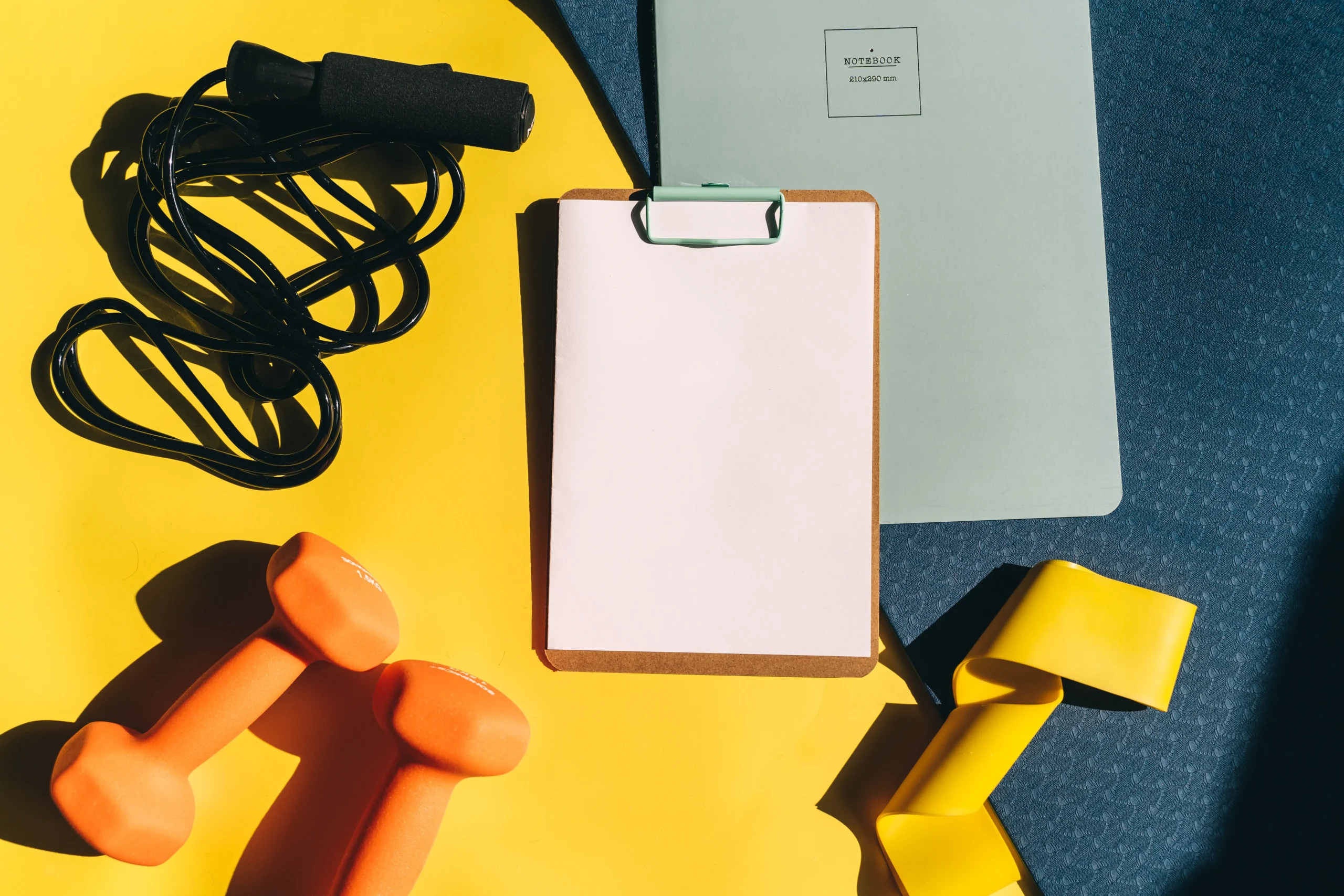 Workout planning clipboard beside gym equipment