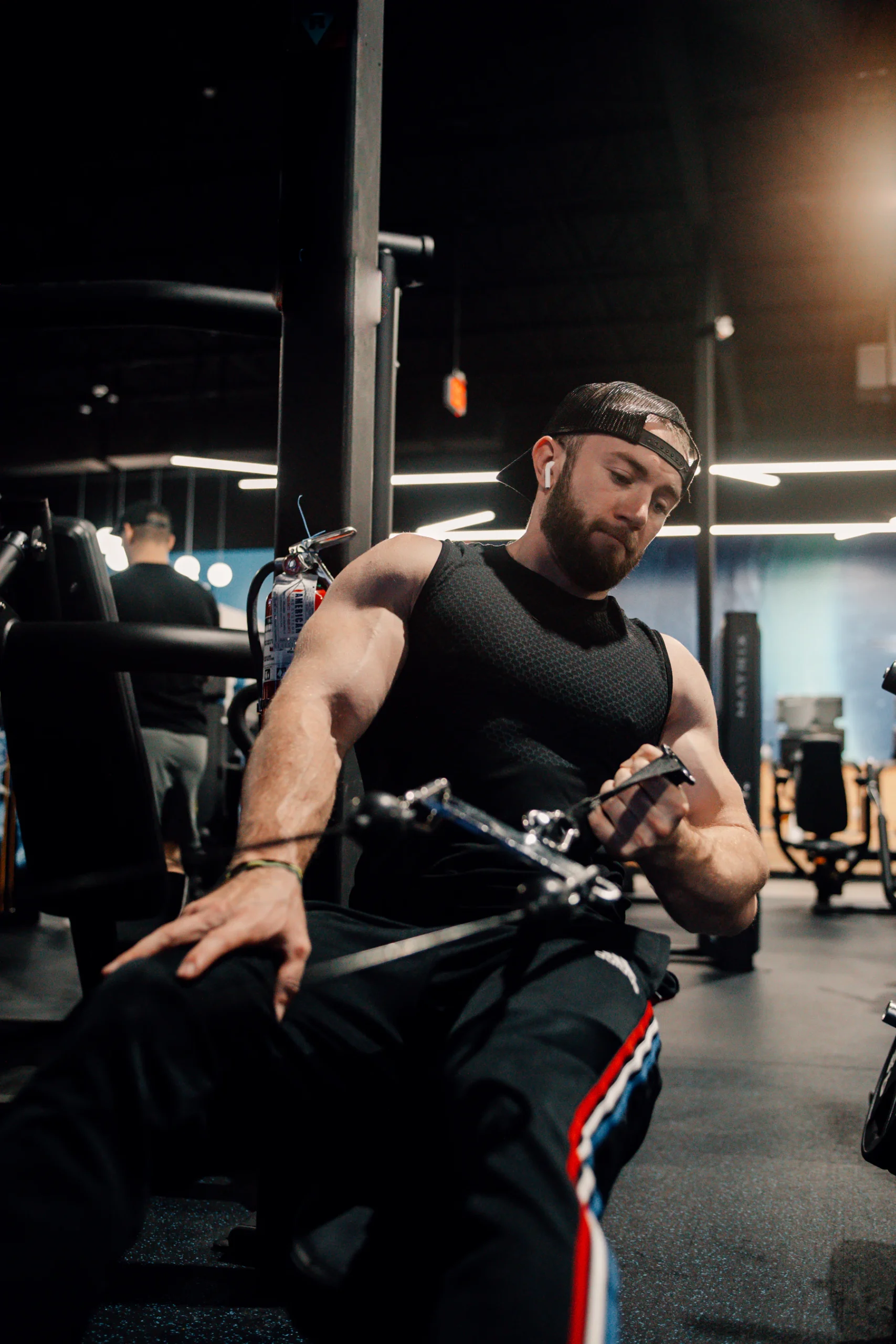 Athlete seated at a cable rowing station for controlled pulling work