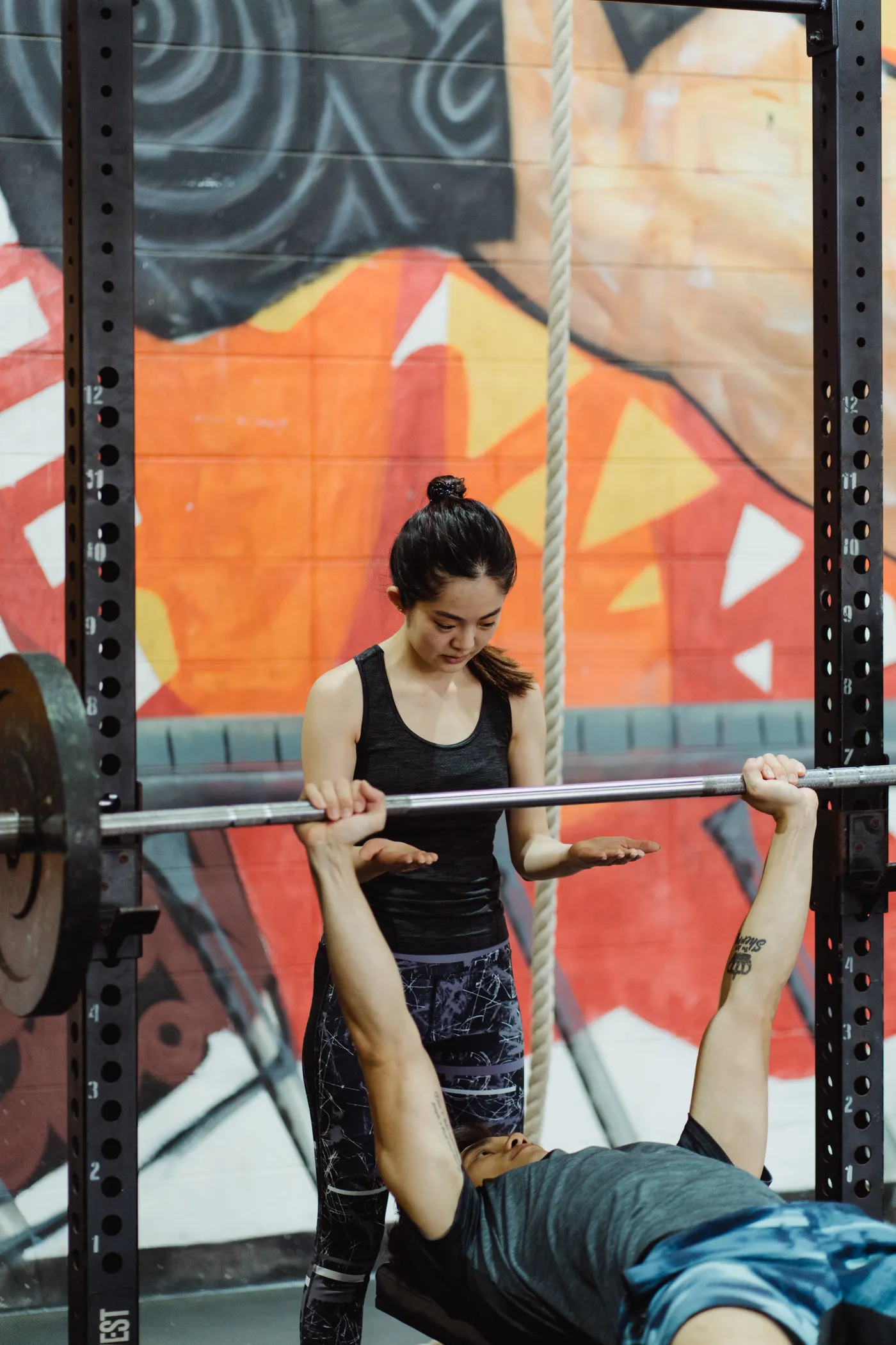 Woman spotting a man during a bench press