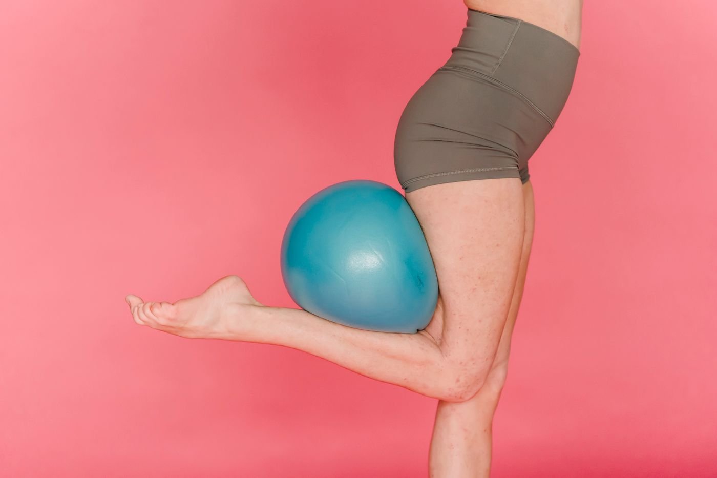 Woman balancing on one leg with a fitness ball