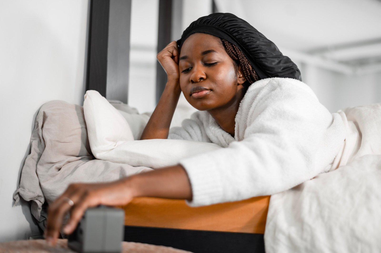 Woman turning off an alarm clock in the morning