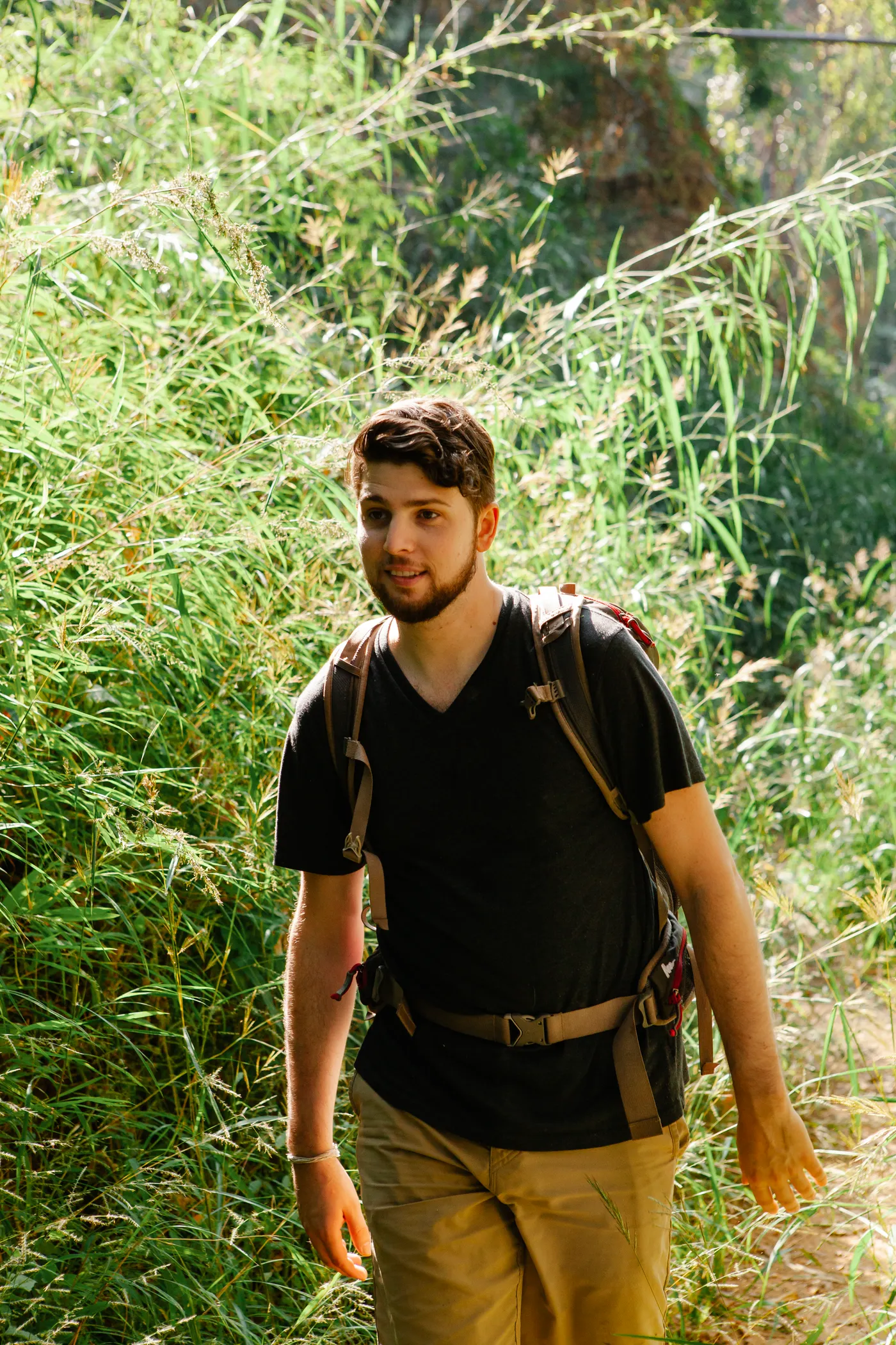 Hiker carrying a backpack while walking through woods