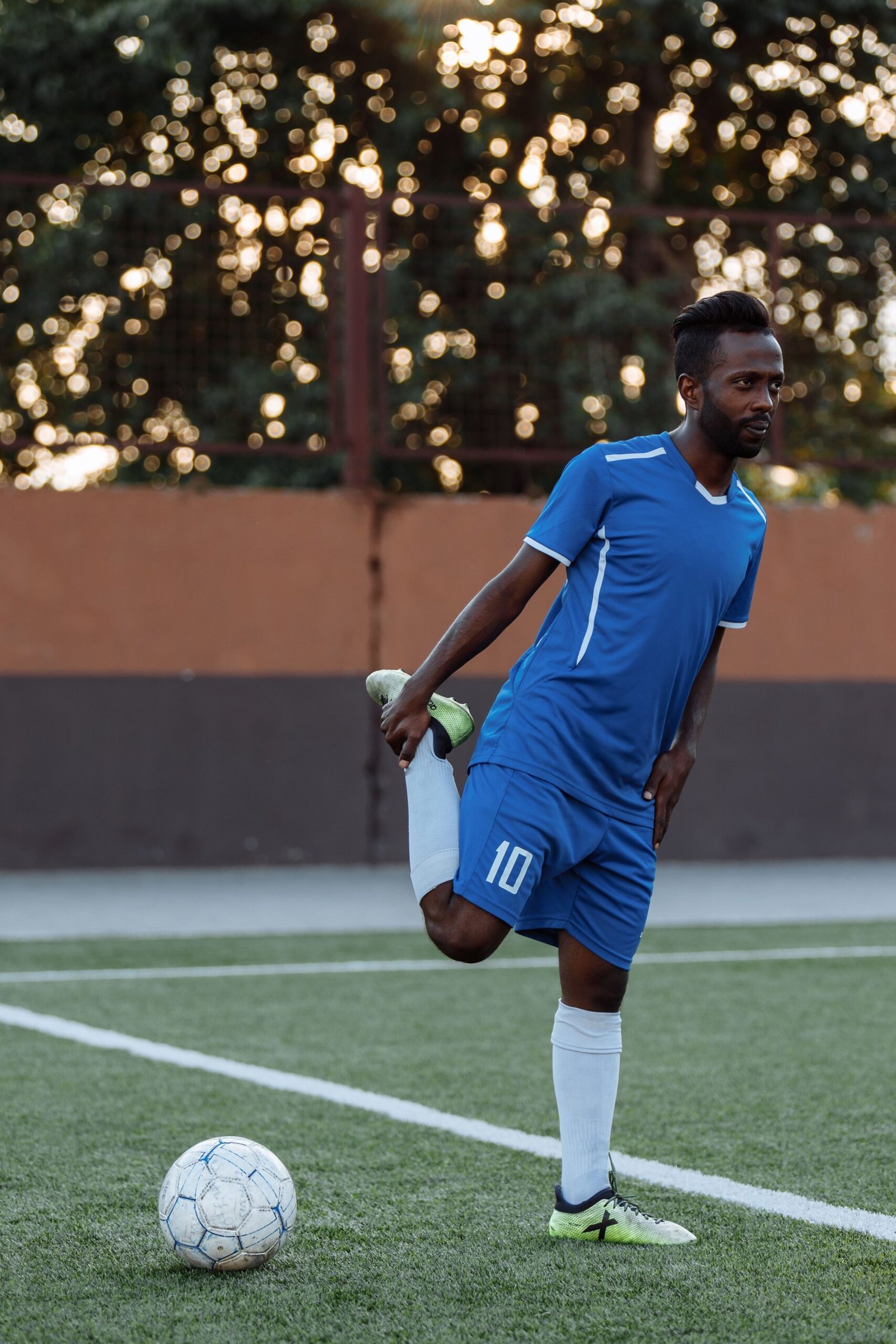 Soccer player stretching his quadriceps before practice