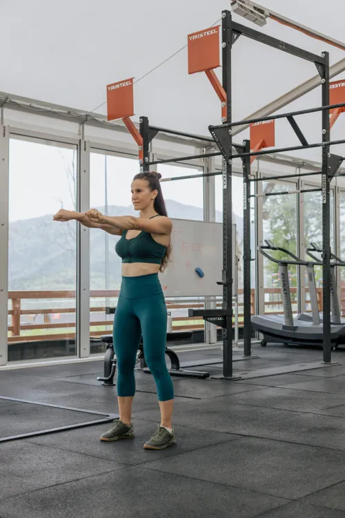 Athlete stretching beside large gym windows