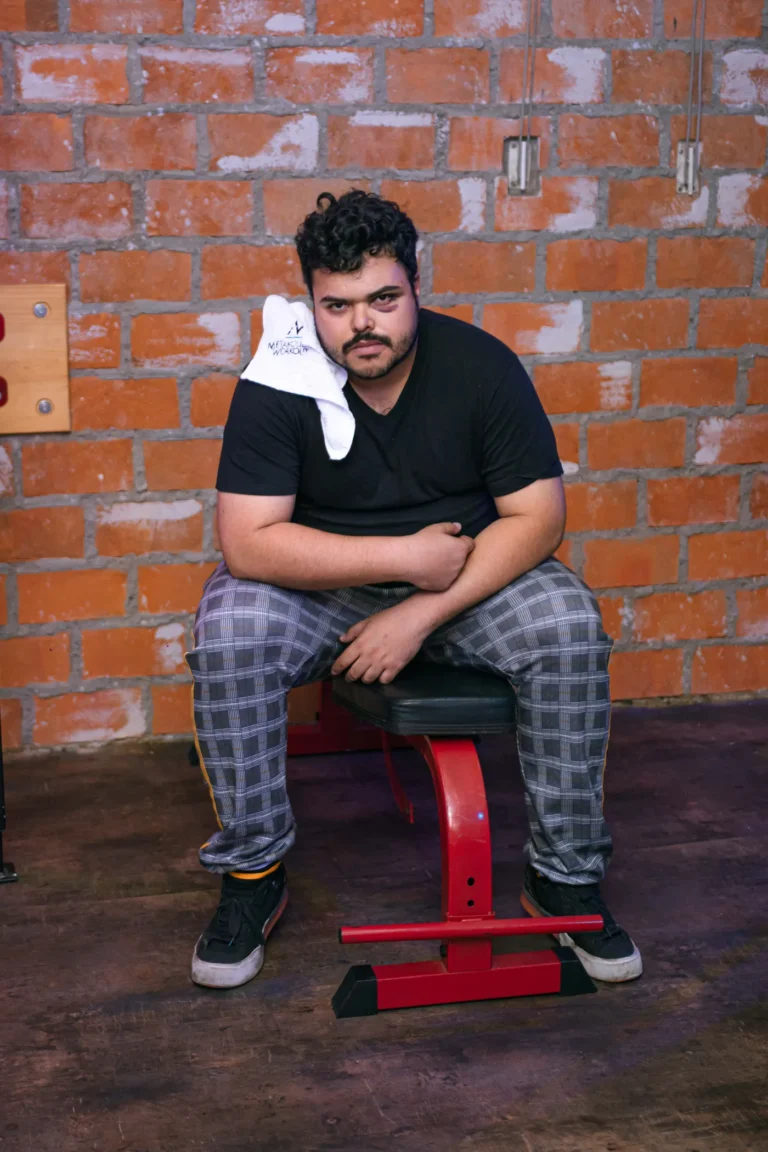 Athlete seated on a gym bench during a break from training
