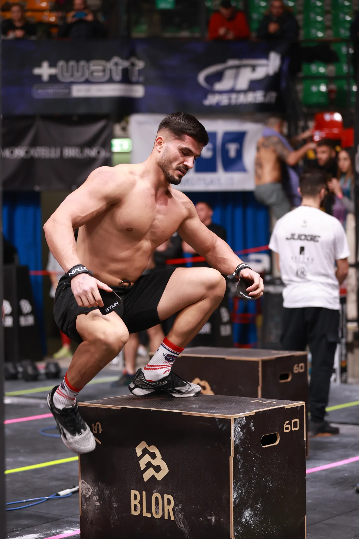 Athlete performing a powerful box jump in a gym
