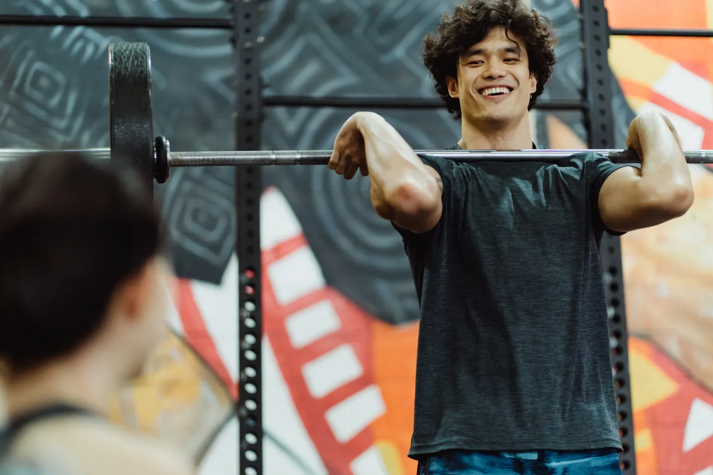 Lifter supporting a barbell across the shoulders in a gym