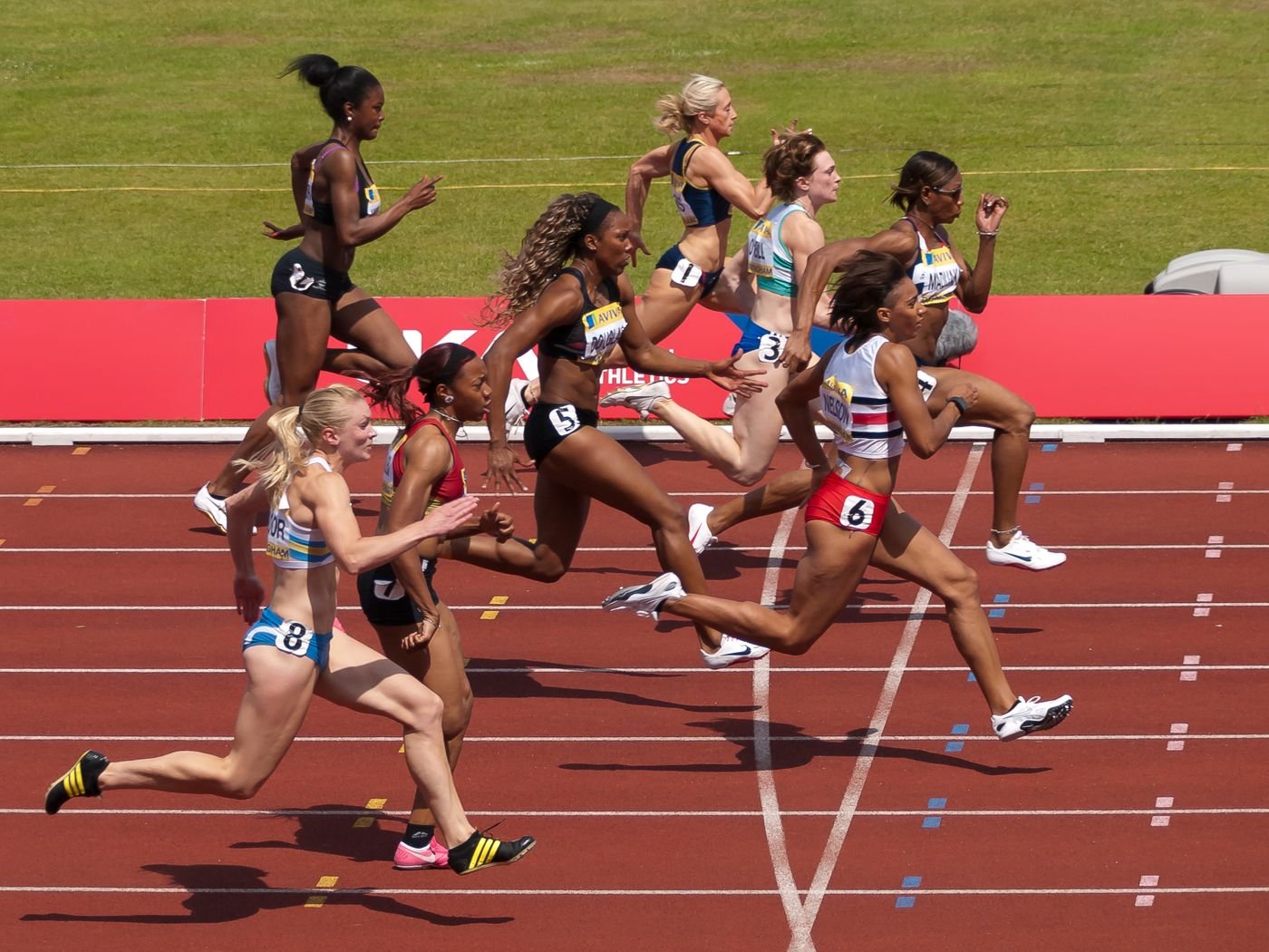Female athletes running on a stadium track