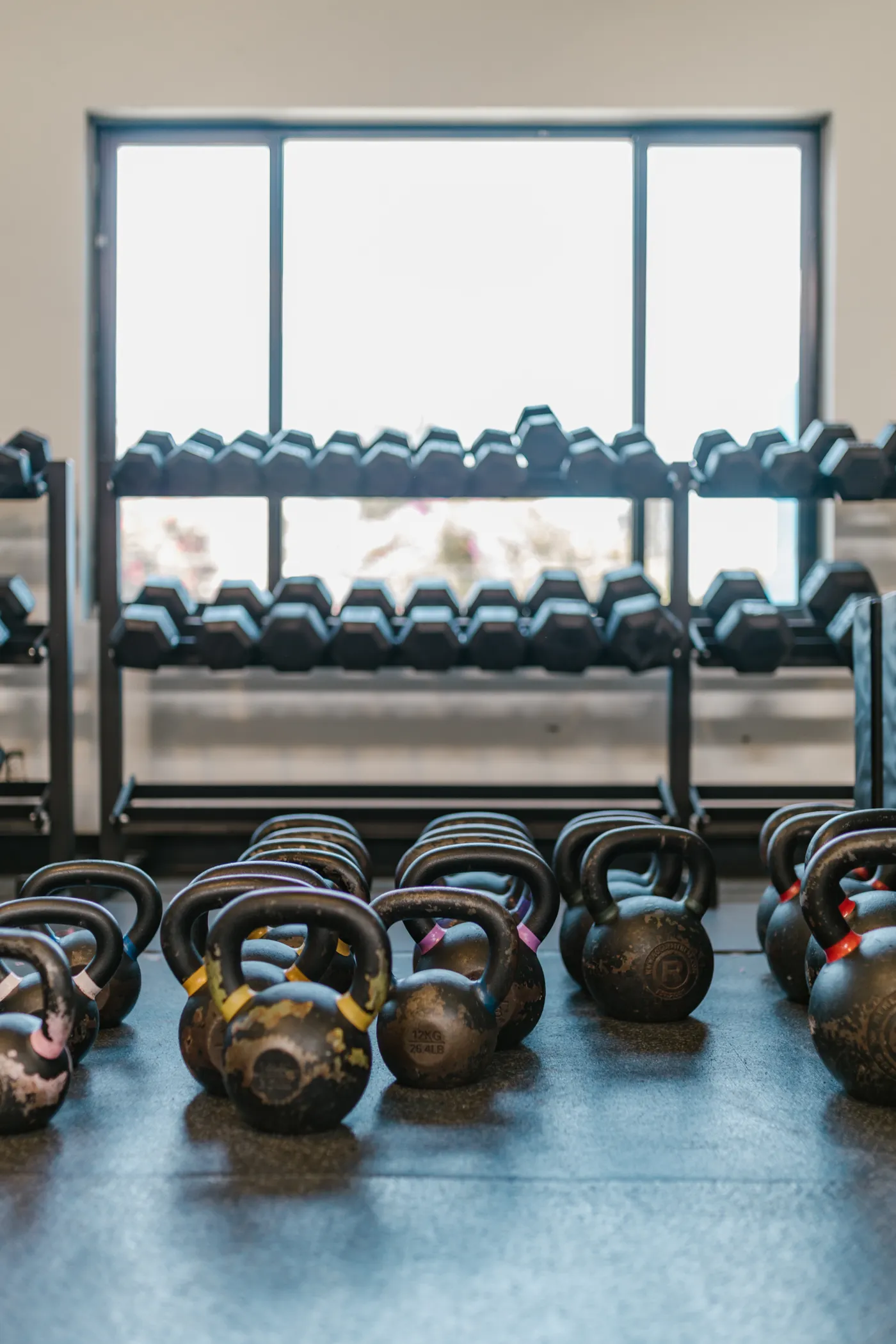 Kettlebells and dumbbells arranged on a gym floor
