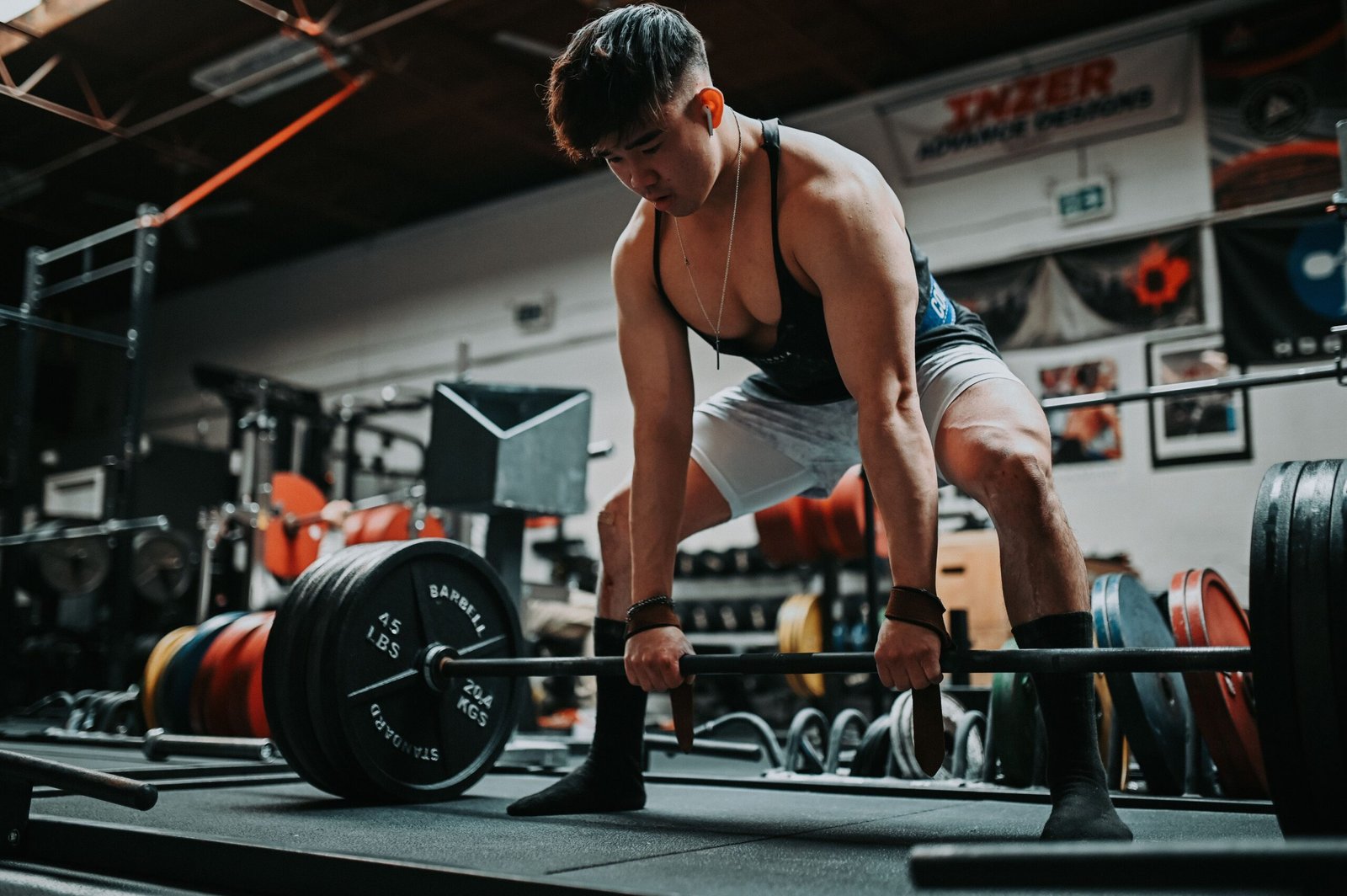 Athlete lifting a loaded barbell from the floor in a weight room