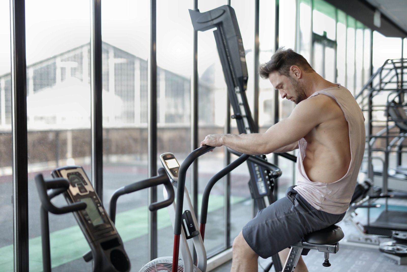 Man pedaling an air bike during a gym conditioning session