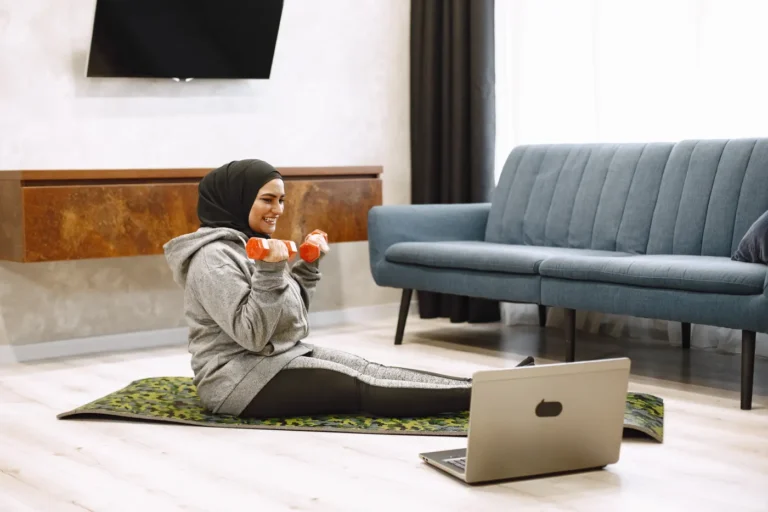 Woman training with dumbbells on a mat in a home setting