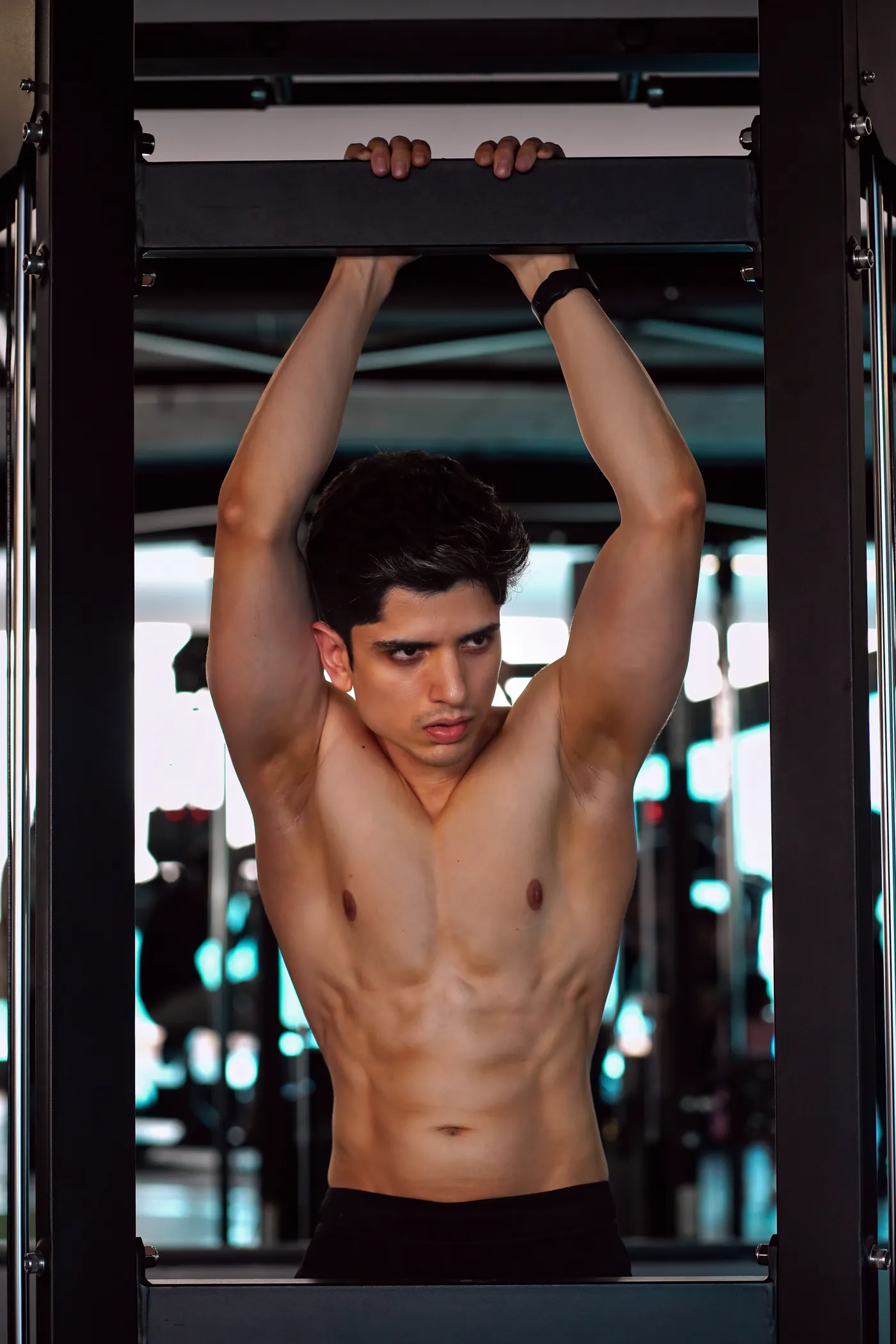 Man performing controlled pull-ups on a gym bar