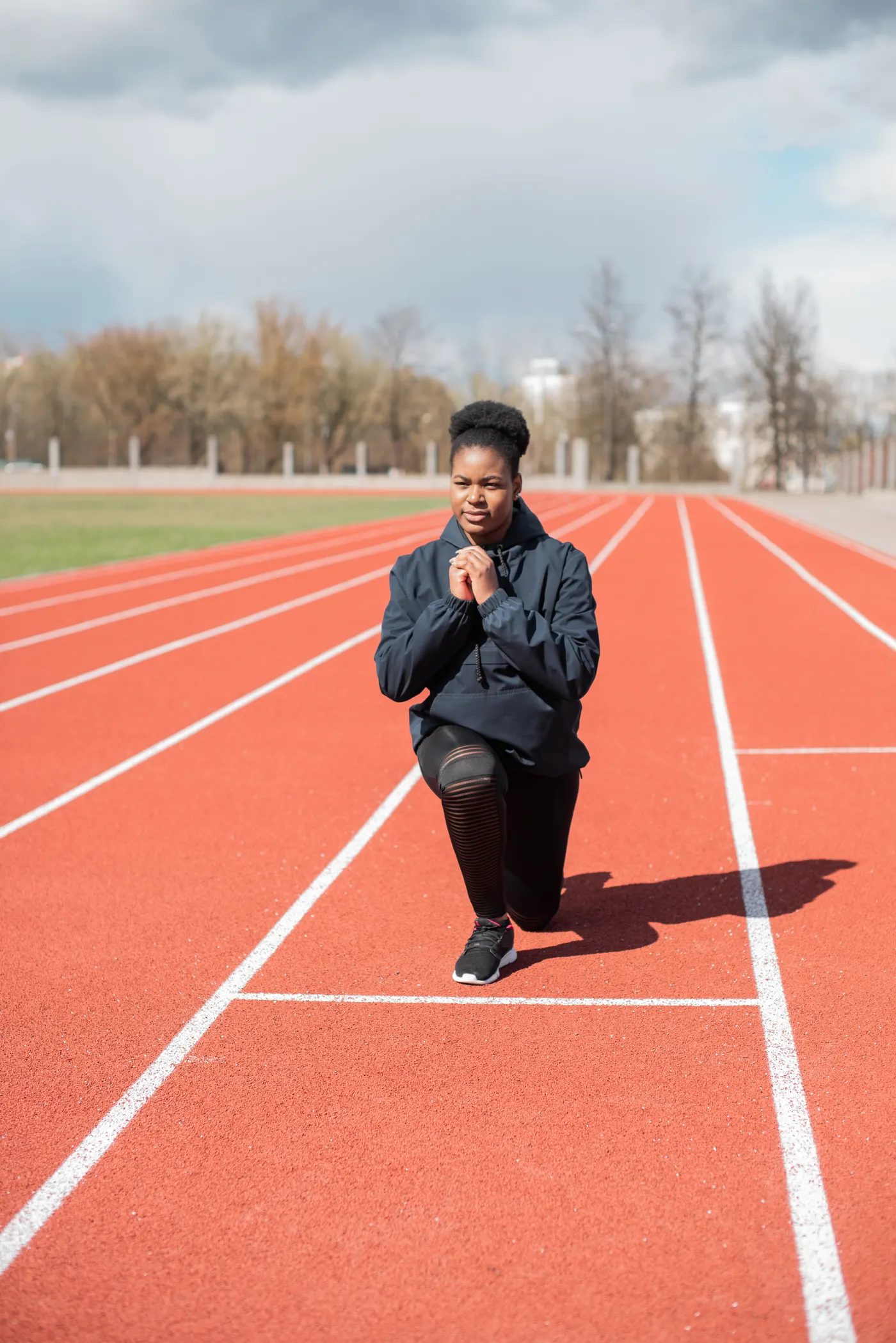 Woman stretching on an athletics track before training