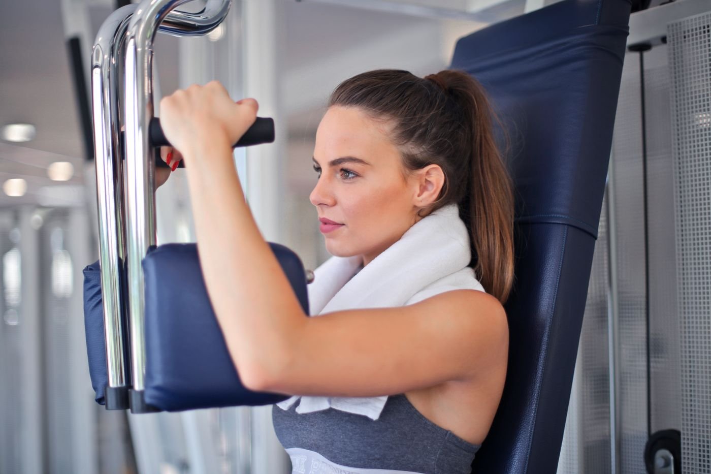 Woman performing a chest press on a gym machine