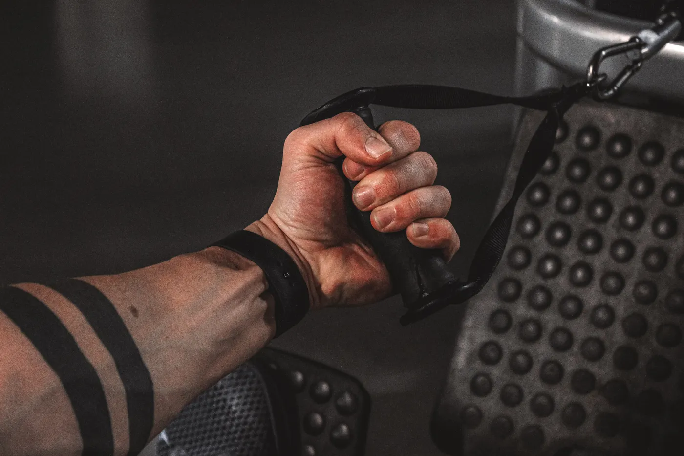 Hand gripping a cable handle during gym training