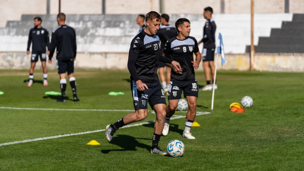Group of young football players training together on a sunny field