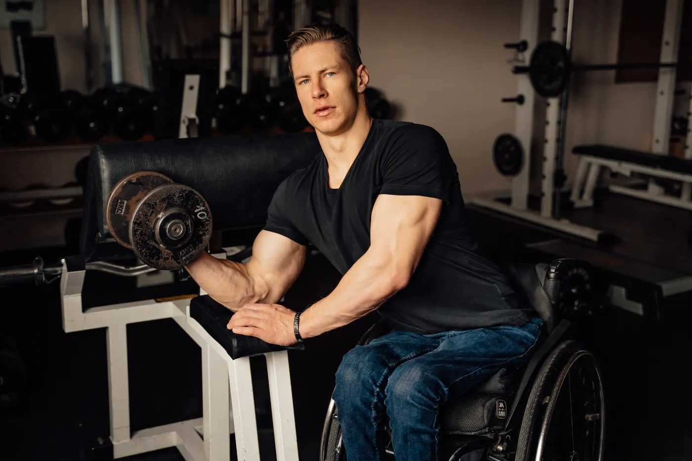 Man performing a controlled dumbbell biceps curl in a gym
