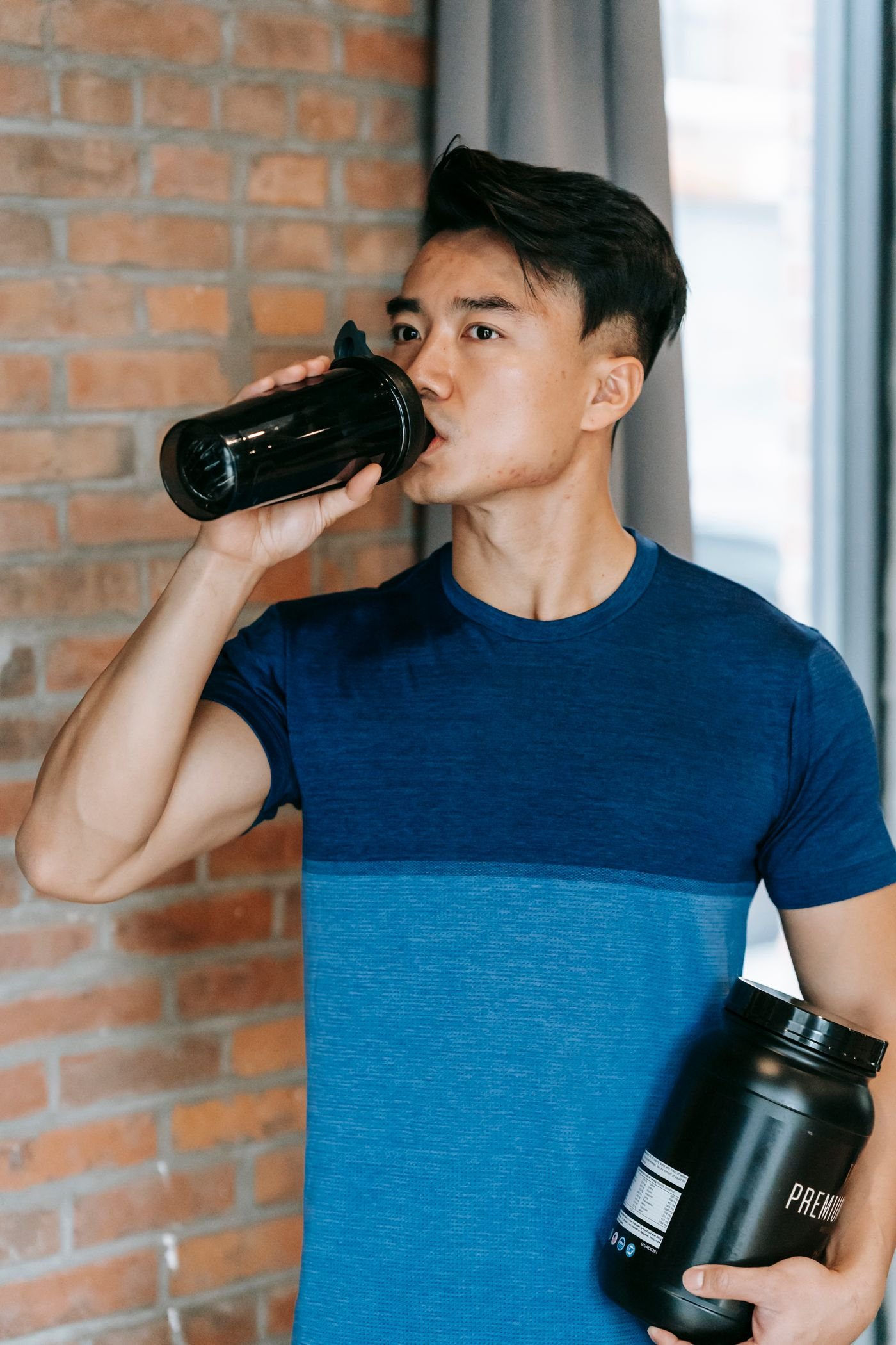 Athlete taking a hydration break in a gym