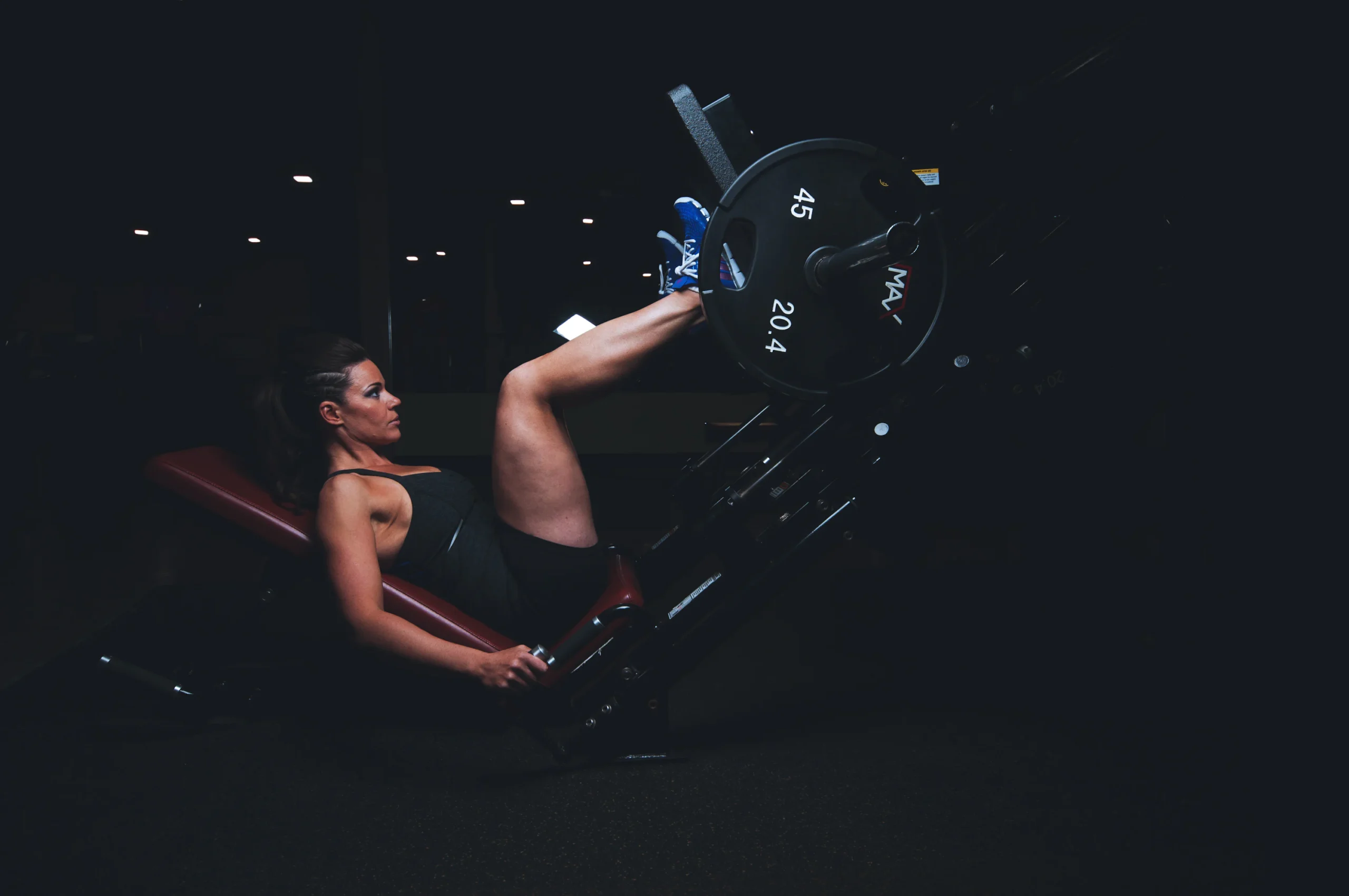 Woman strength training on a gym machine as part of a full-body routine