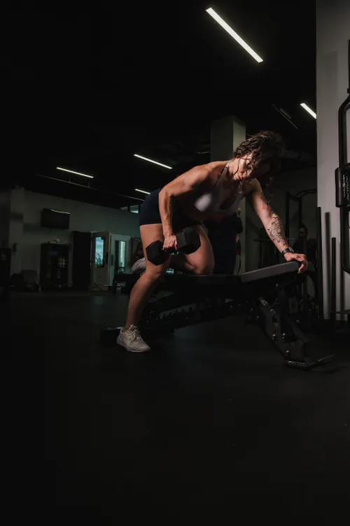 Woman training her biceps with a dumbbell in the gym