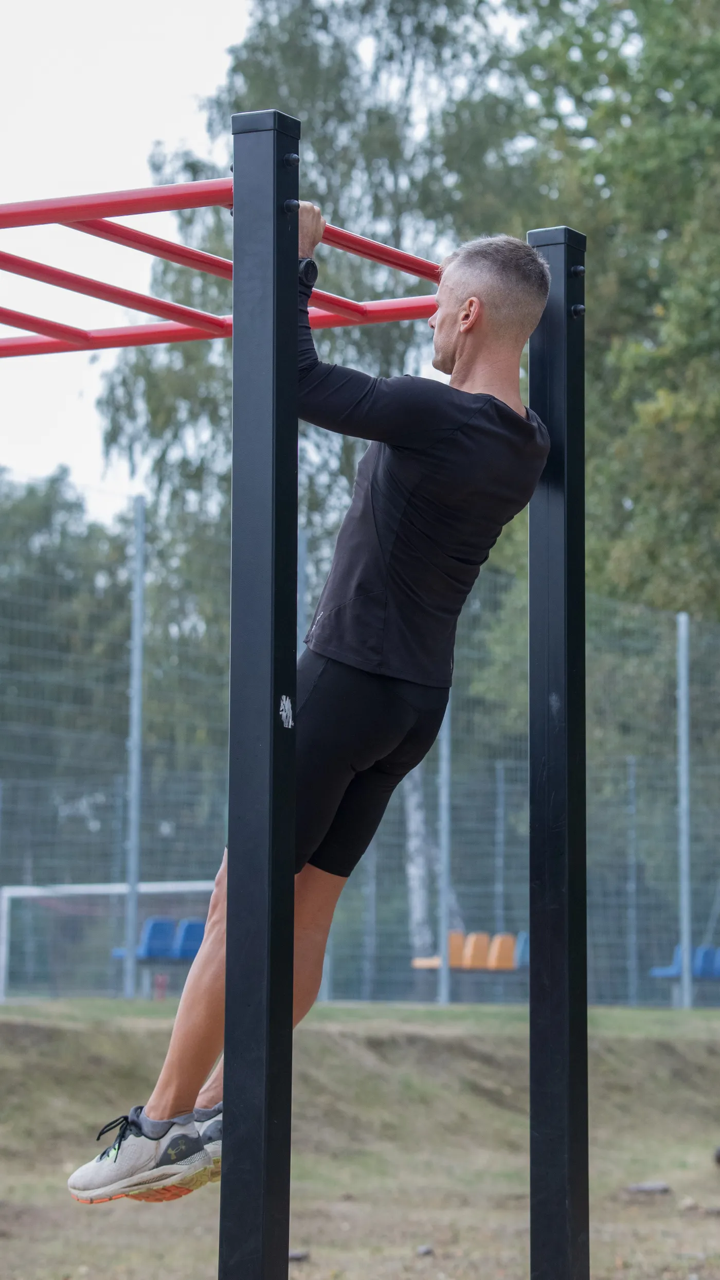 Athlete training on a pull-up bar in an outdoor park