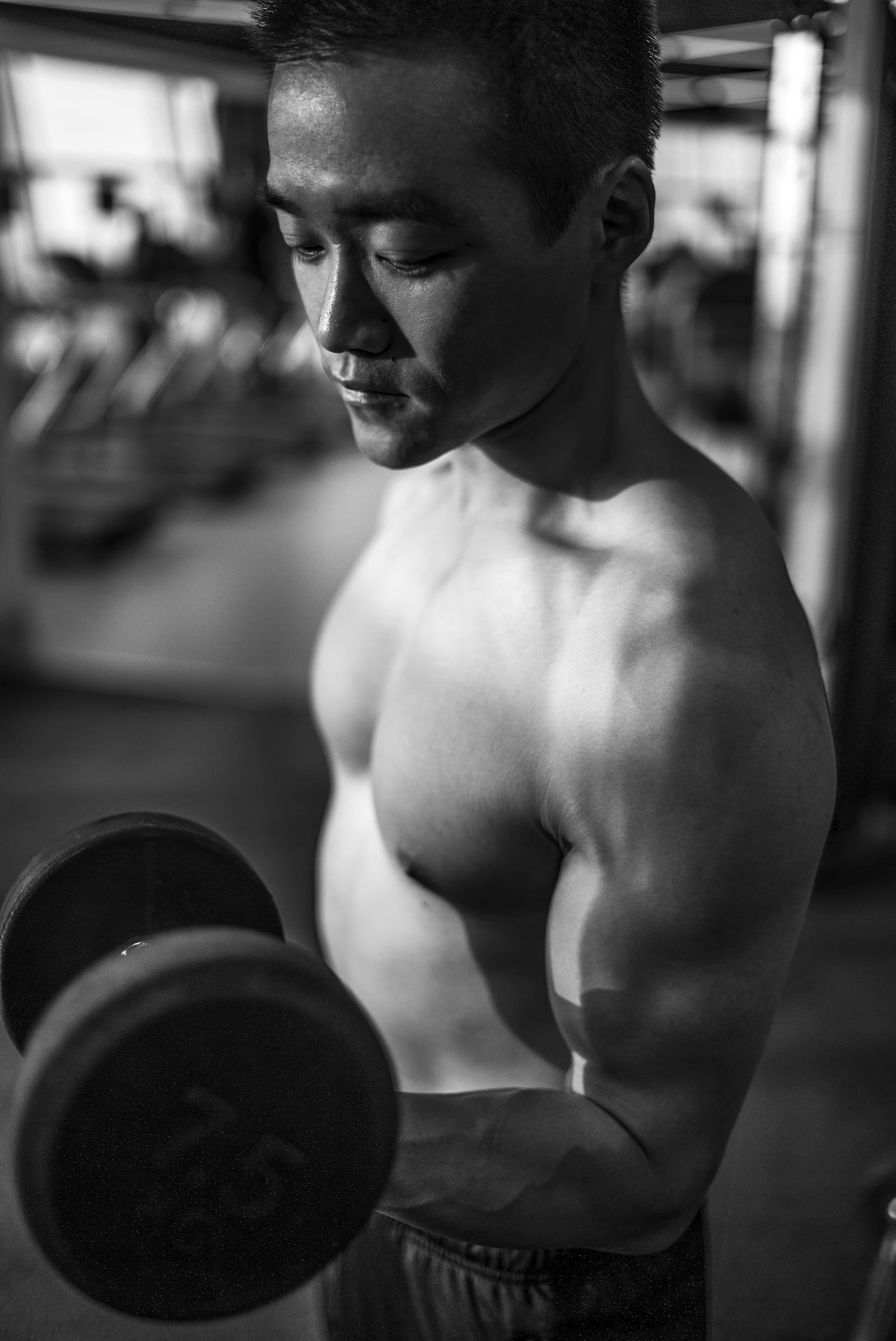 Man lifting a dumbbell in a gym during arm training