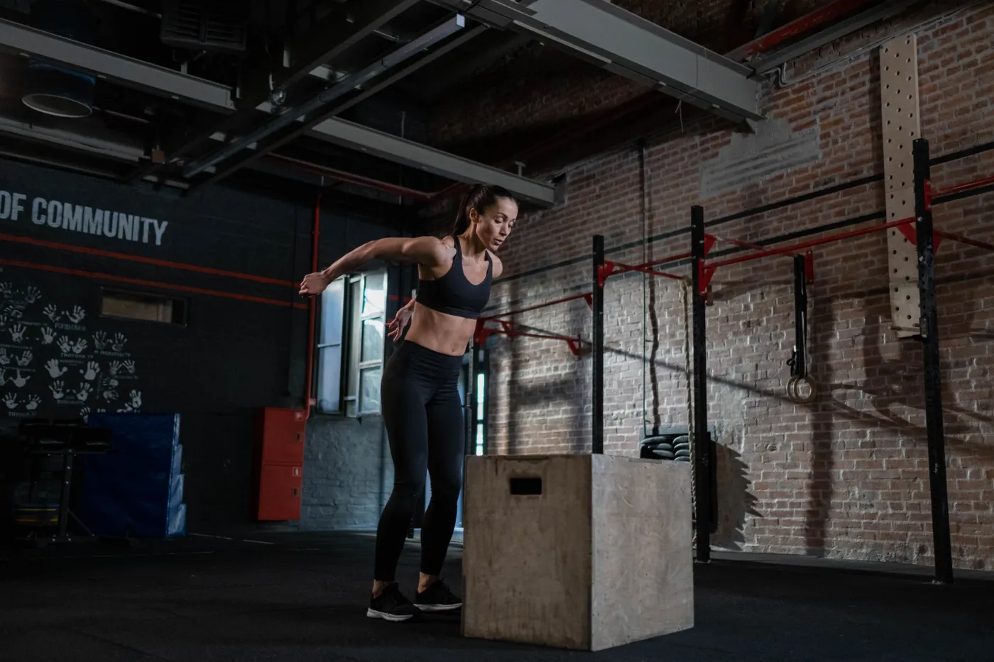 Athlete performing a controlled plyometric box jump in a gym