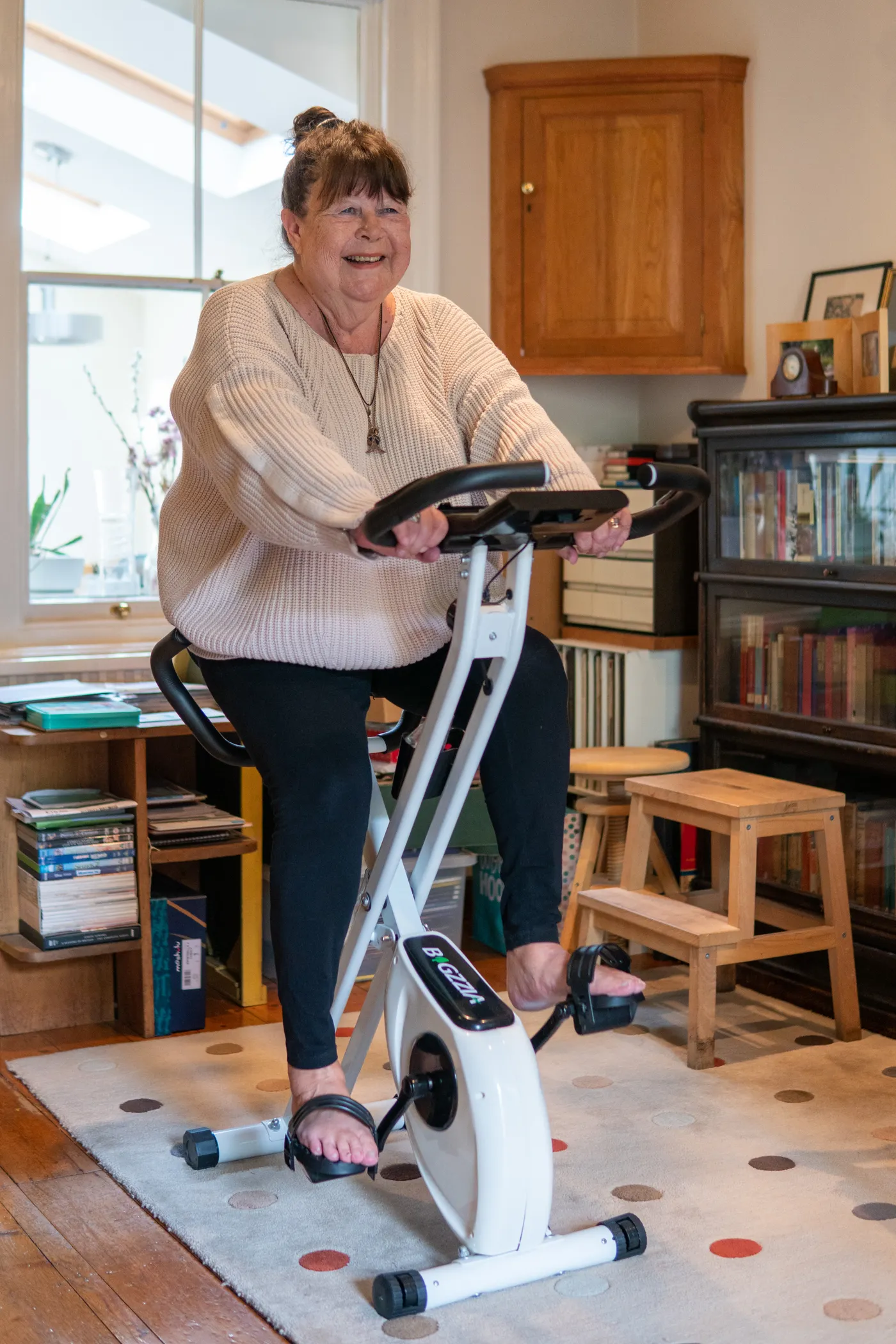 Woman riding a stationary exercise bike indoors