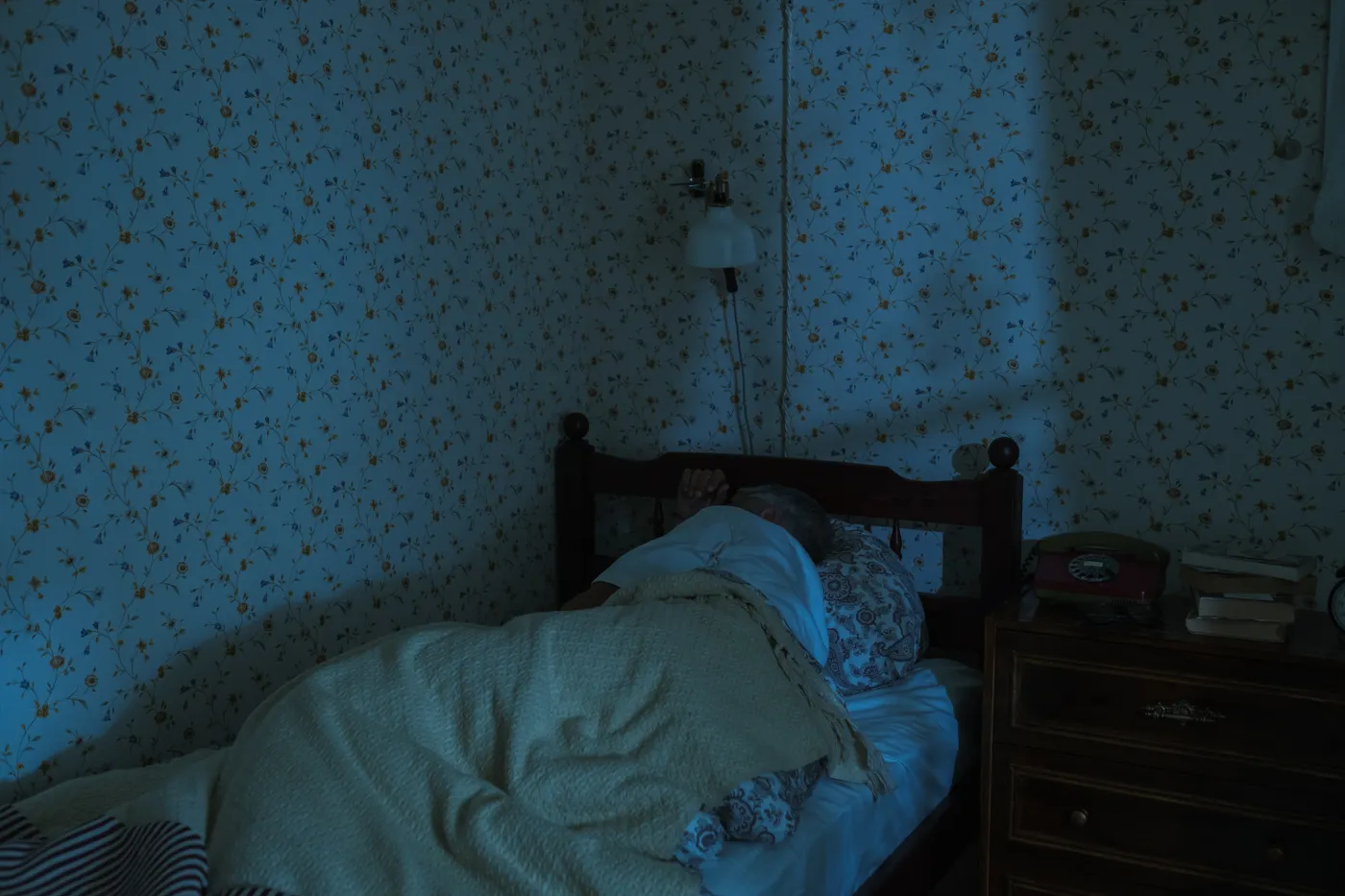 Older man sleeping peacefully in a softly lit bedroom