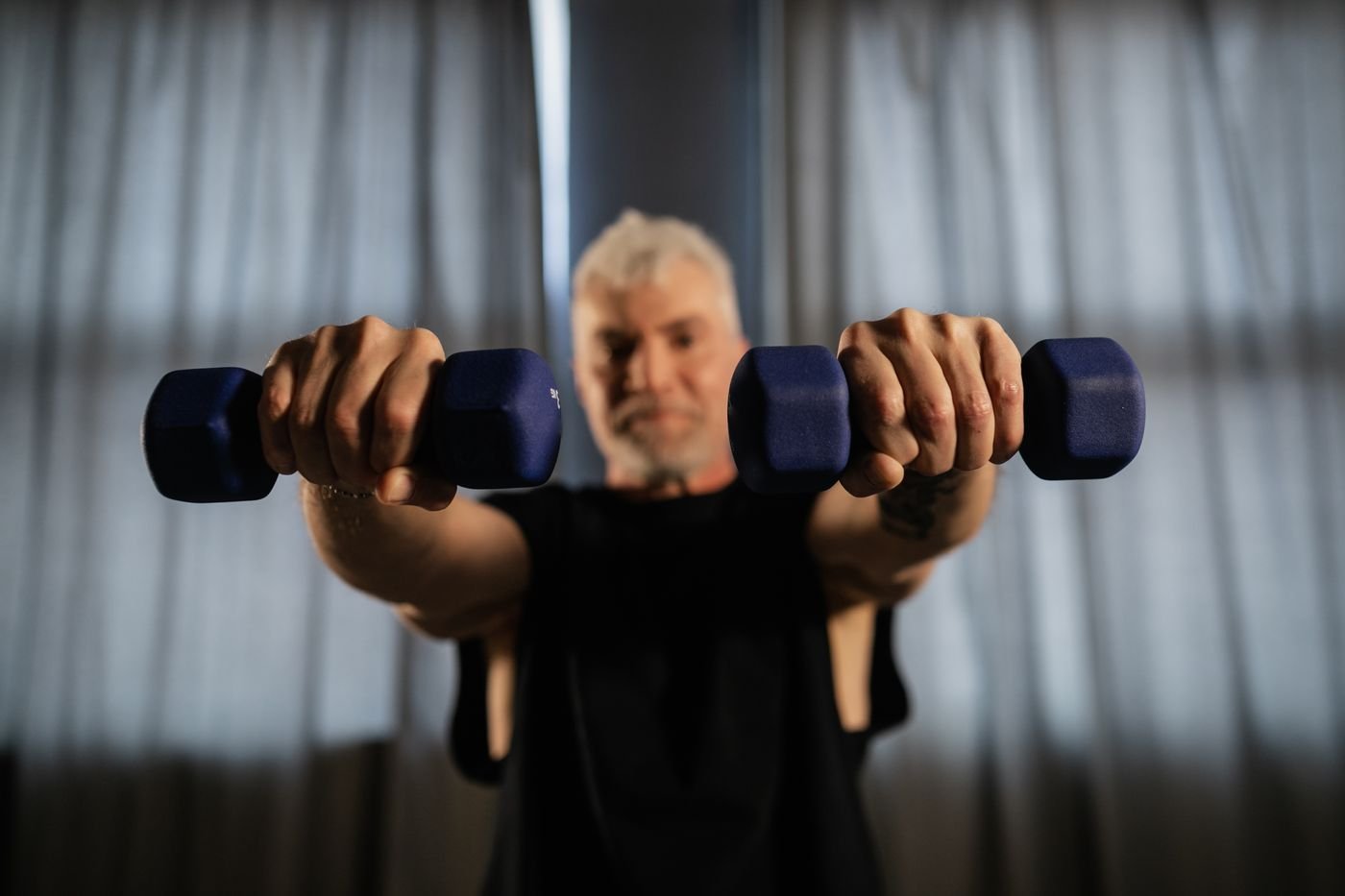 Senior man lifting dumbbells as part of a strength training routine
