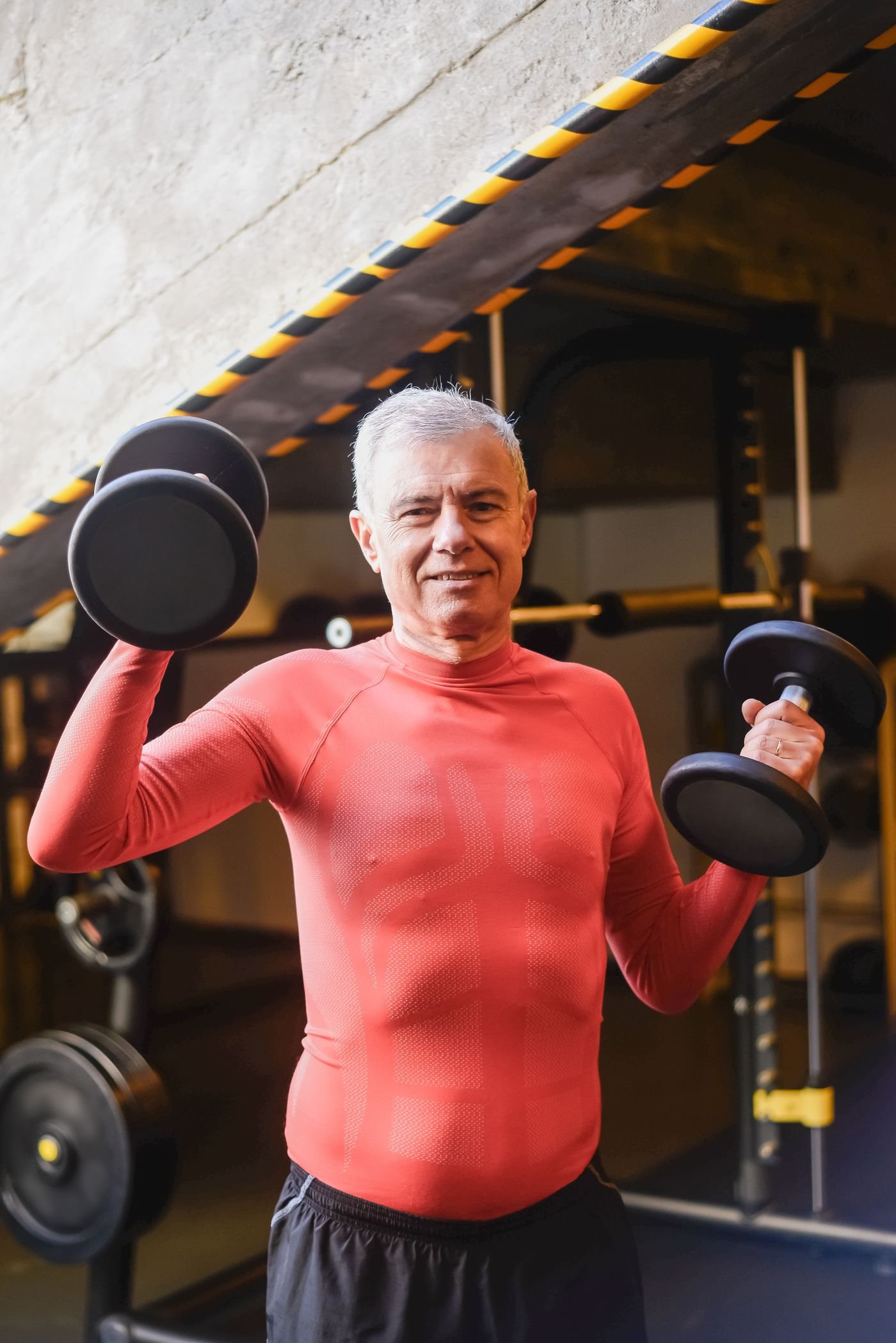 Older man lifting dumbbells during a workout