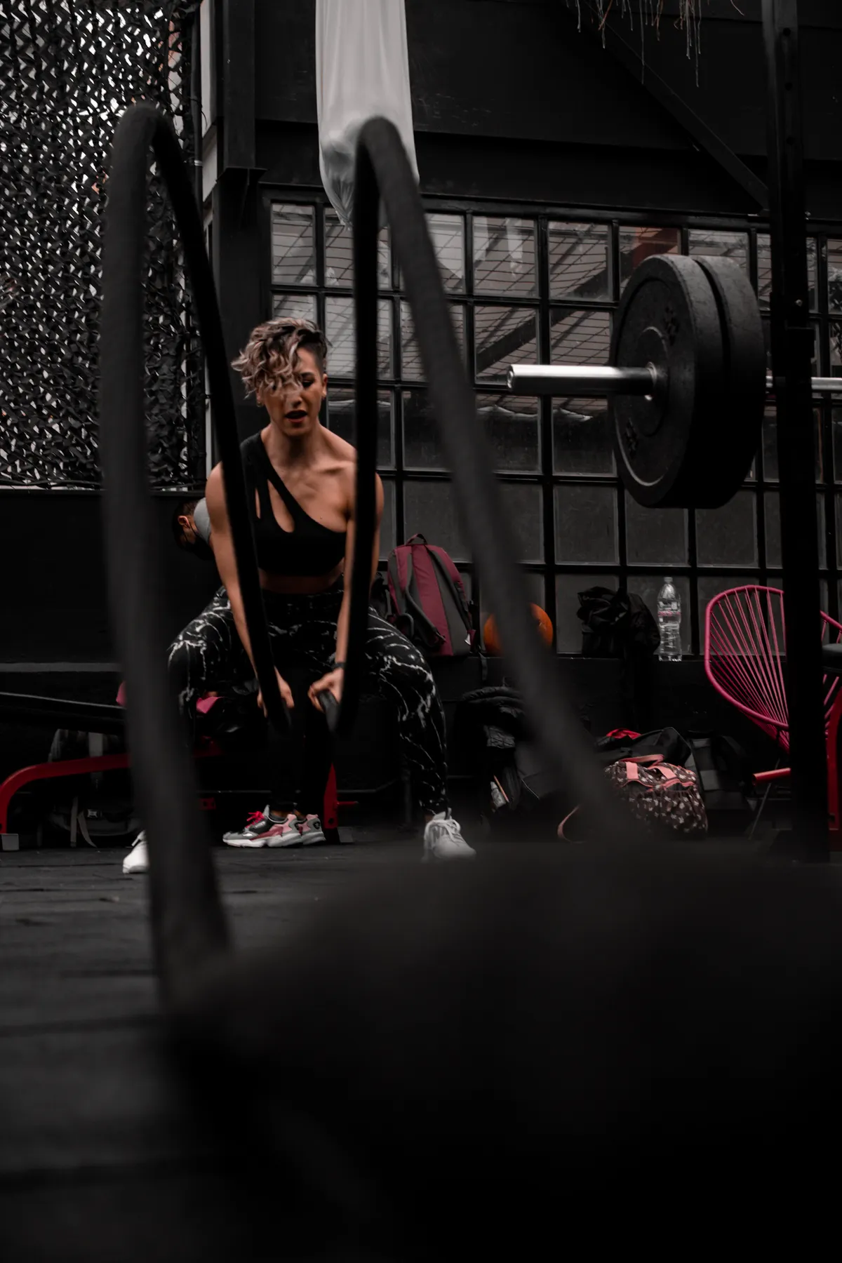 Woman driving battle-rope waves during a gym workout