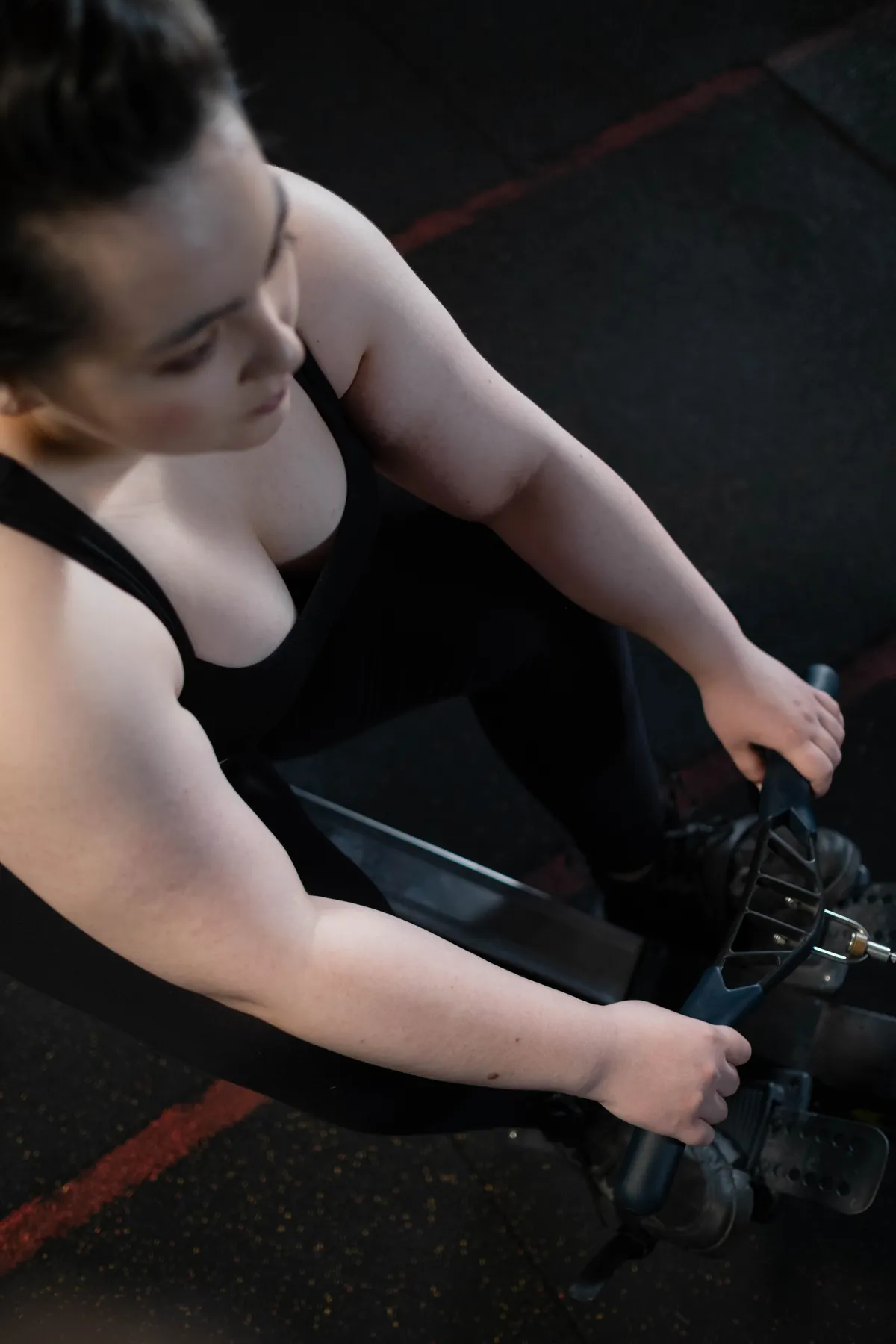 Woman exercising on a rowing machine in a gym
