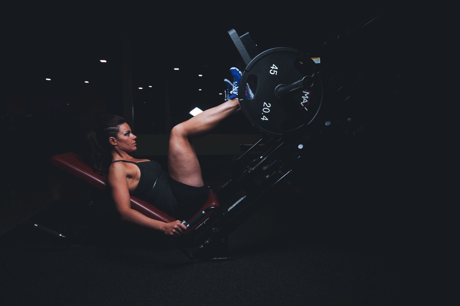 Woman pressing a gym leg machine with her feet