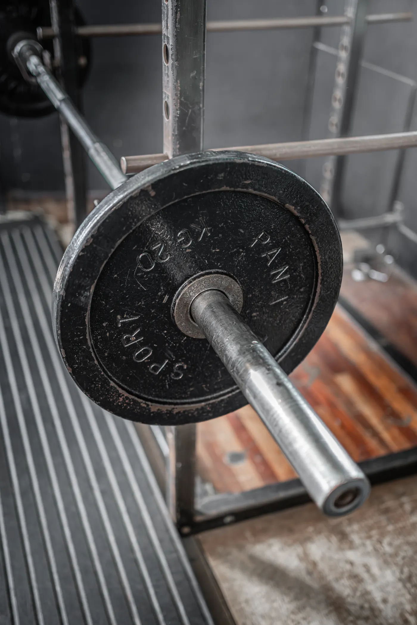 Loaded barbell resting in a gym squat rack