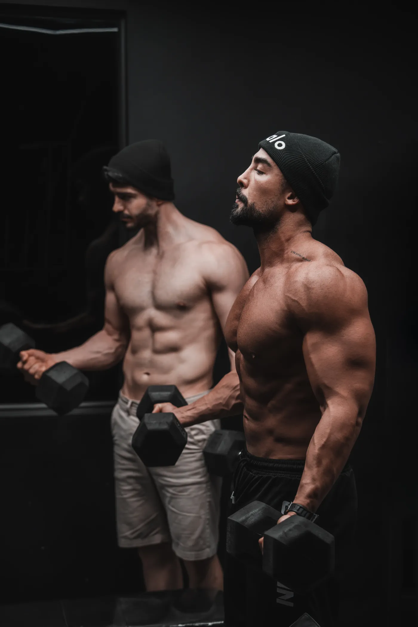 Two men training with dumbbells in a gym